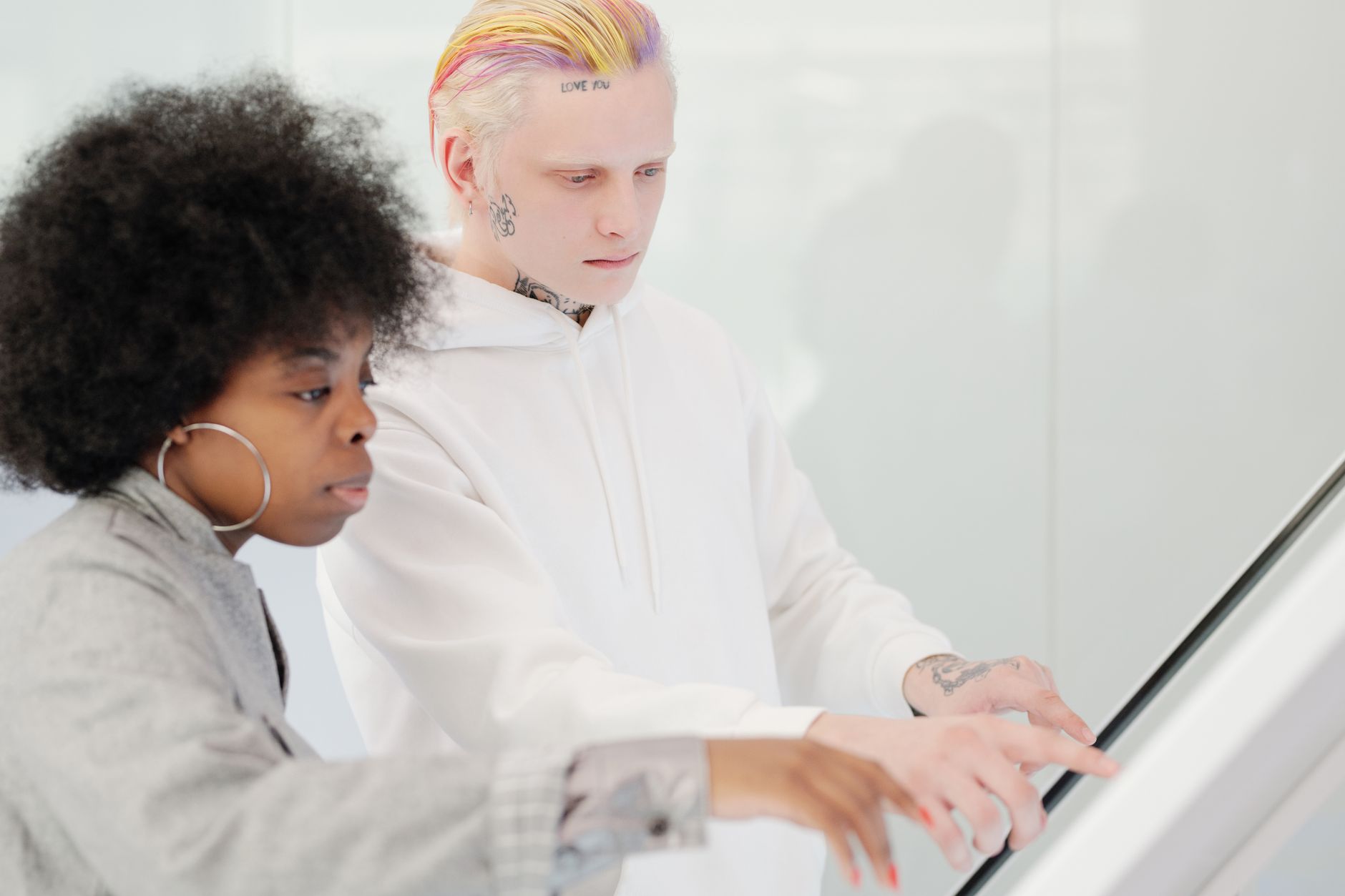 Two people collaborating at a touchscreen, focusing on technology and teamwork.