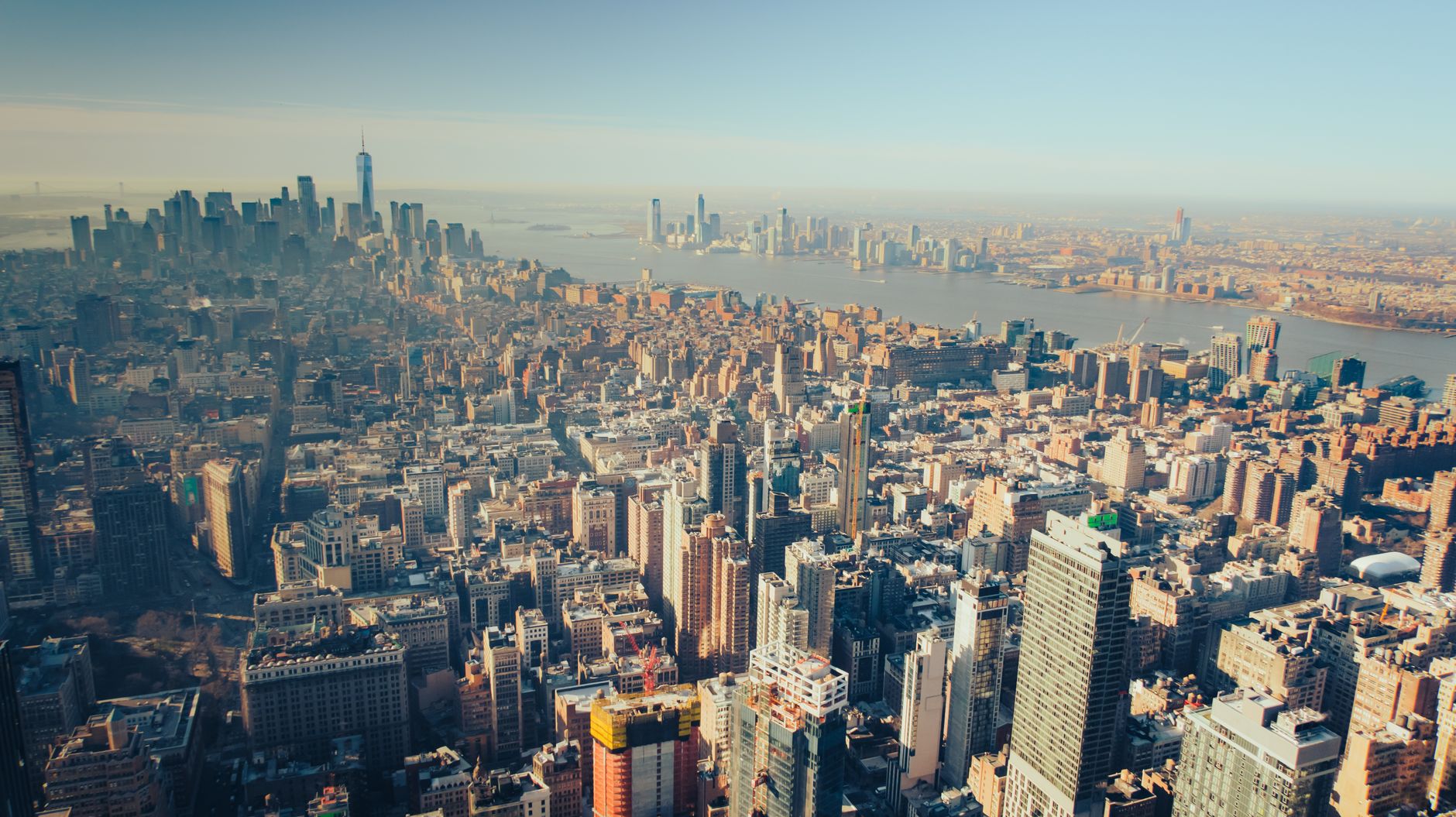 A stunning aerial view of the New York City skyline under the bright day sky.