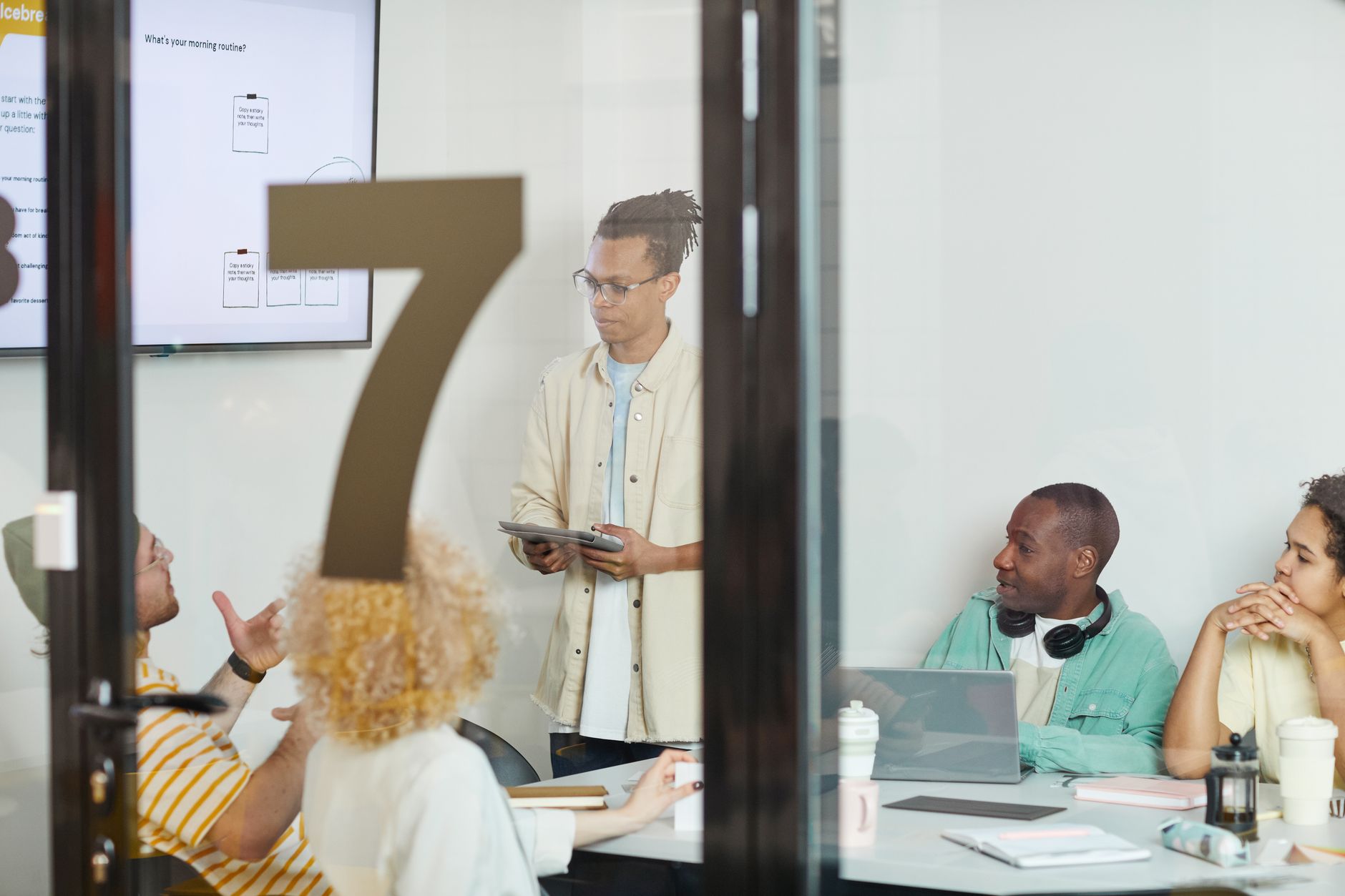 A diverse team collaborates in a modern conference room, engaging in a planning session.