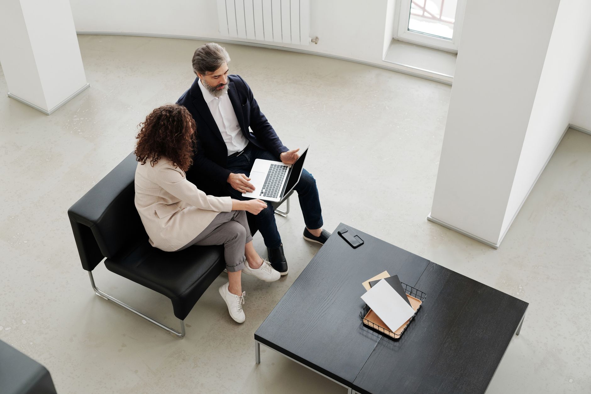 Two business professionals collaborating in a sleek, minimalist office setting.