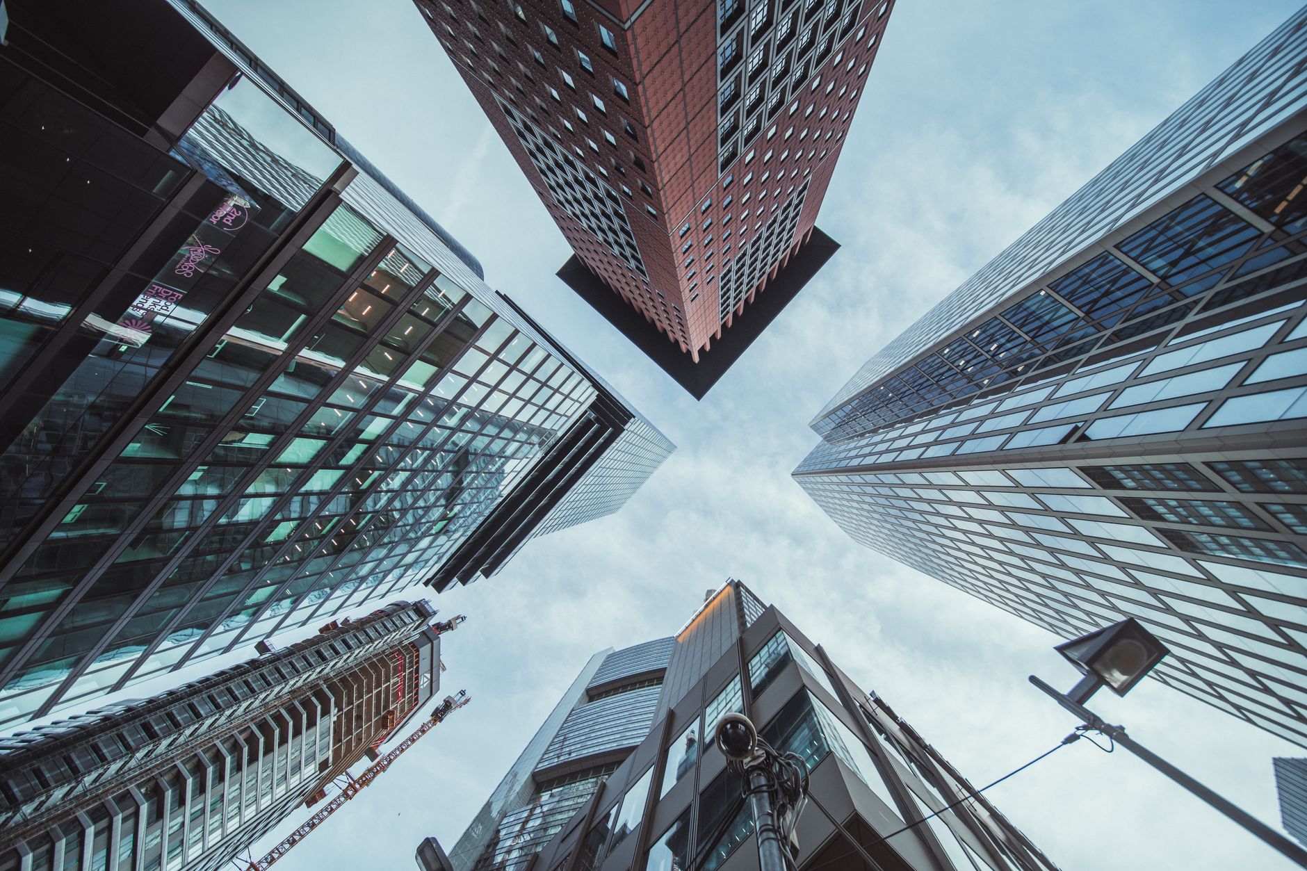 Dramatic upward perspective of skyscrapers against a clear sky in a bustling city center.