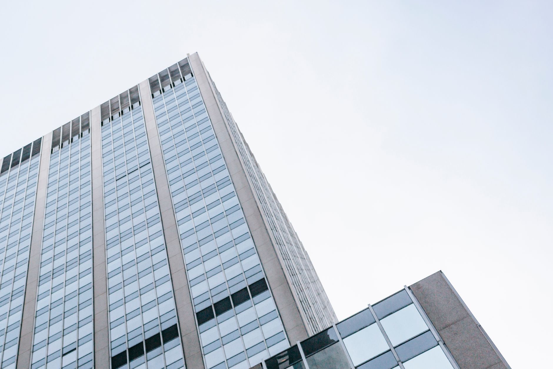 From below of exterior of contemporary high rise building against cloudless blue sky in daytime