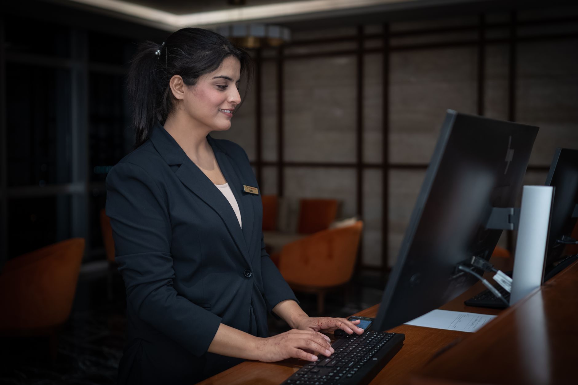 A female receptionist working at a hotel front desk in Islamabad, Pakistan.