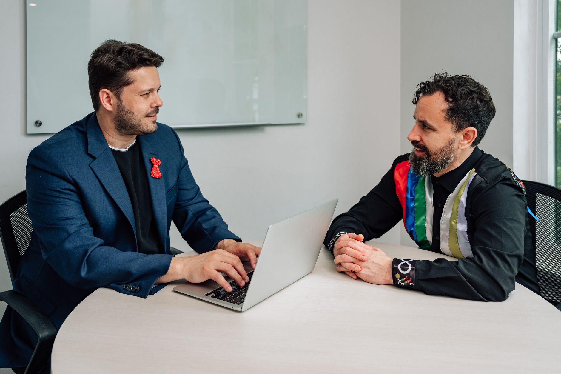 Two men engaged in a collaborative business discussion in a modern office setting.