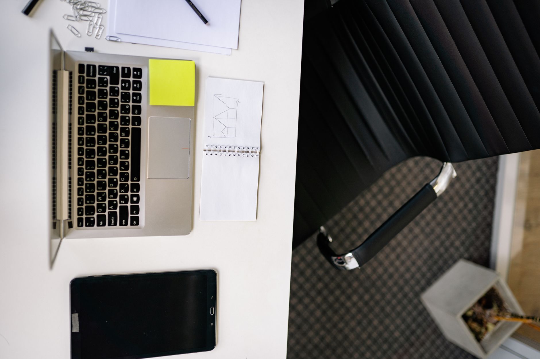 Top view of a neat office desk with a laptop and tablet, creating a modern workspace.
