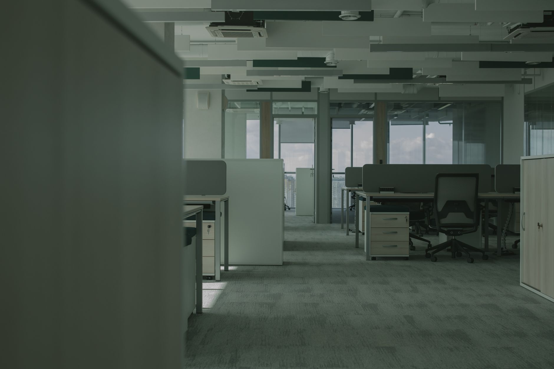 Spacious empty office featuring modern desks, chairs, and partitions.