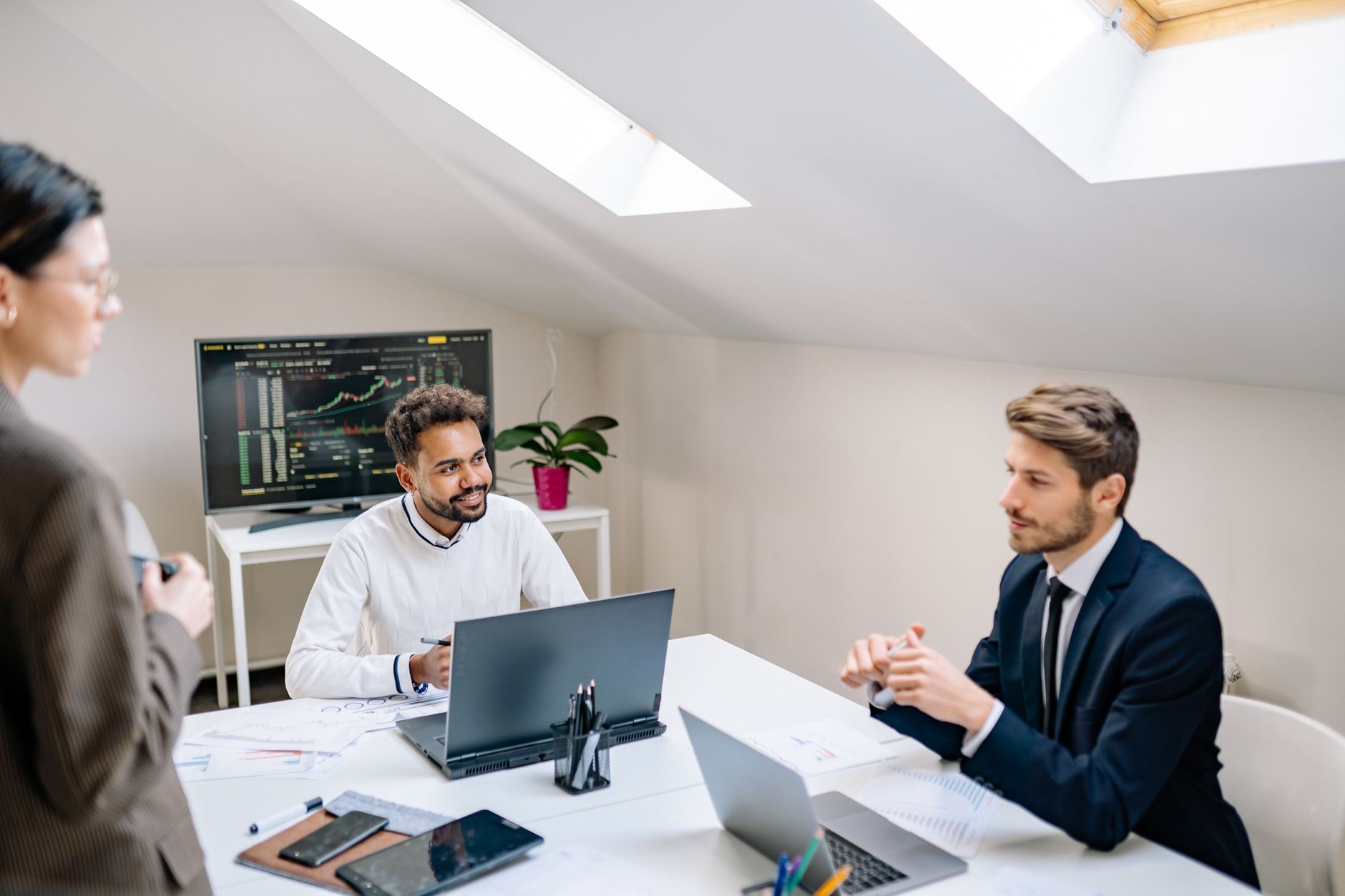 Professional team discusses financial data in bright, modern office setting.