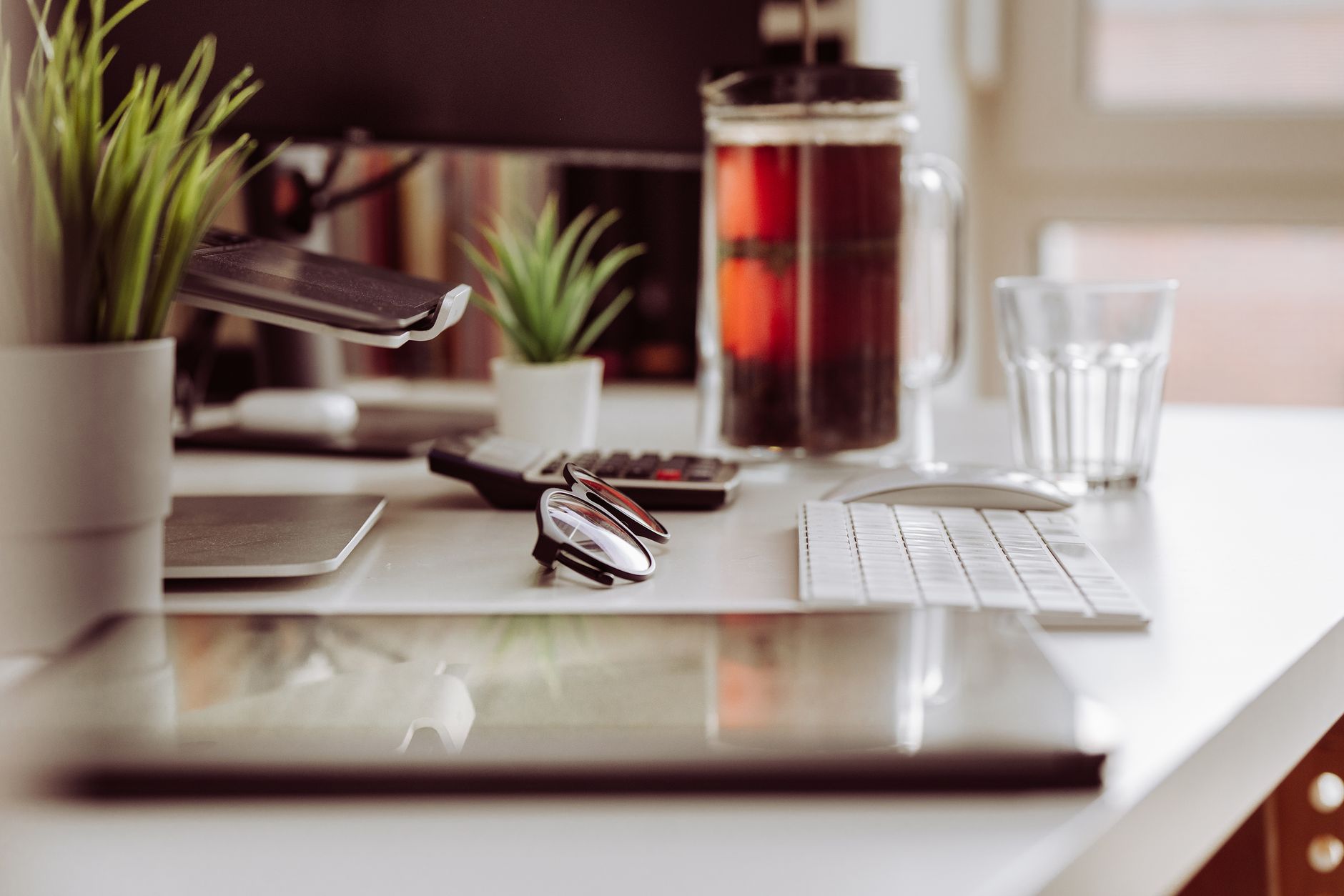 Contemporary home office setup with plants, a graphic tablet, and a computer, creating a cozy work environment.