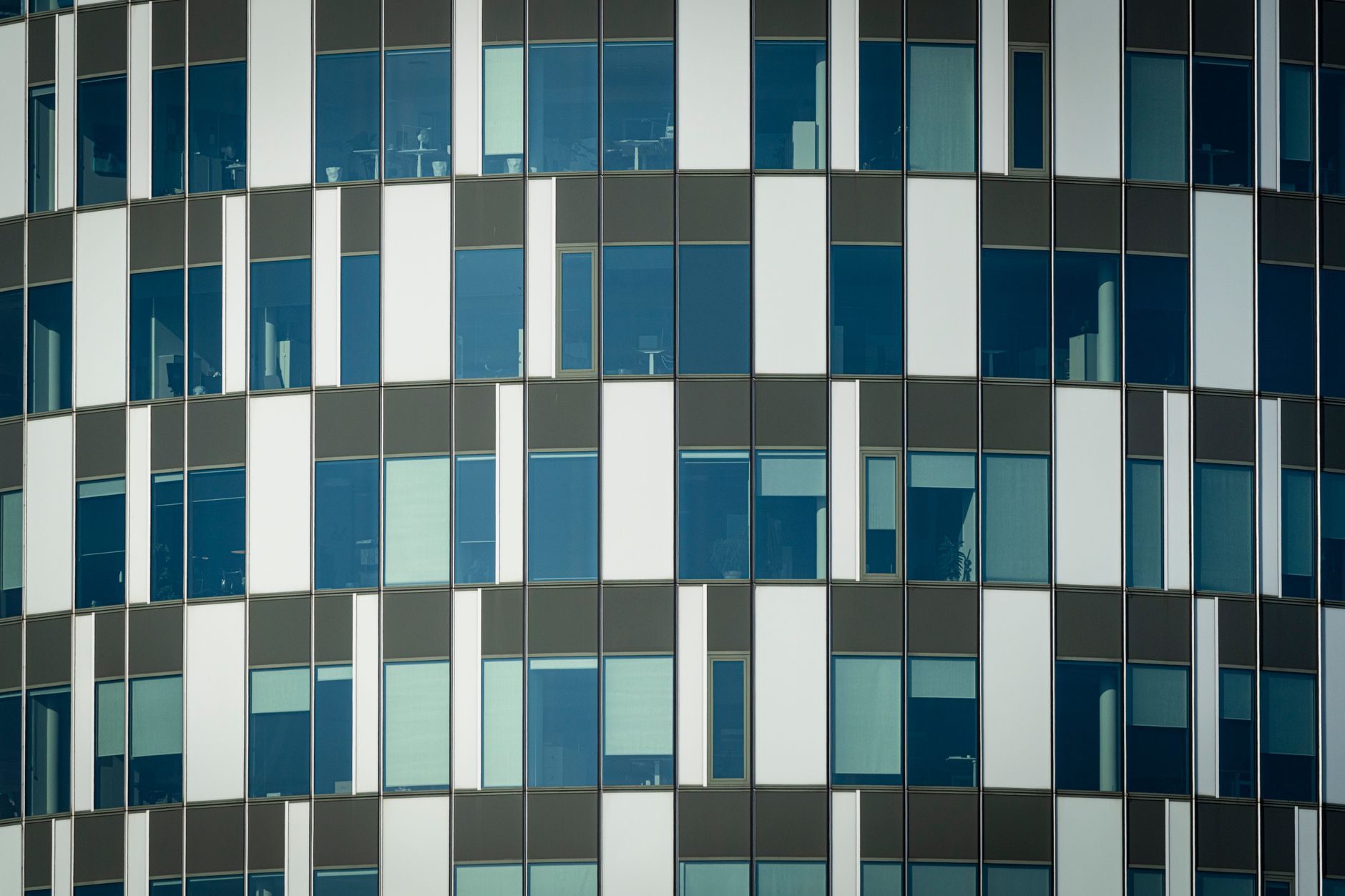 Close-up of a modern office building facade with geometric patterns and glass windows.