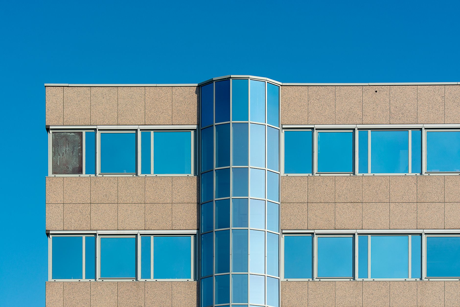 Close-up of a modern office building facade with blue glass windows in Voorburg, Zuid-Holland.