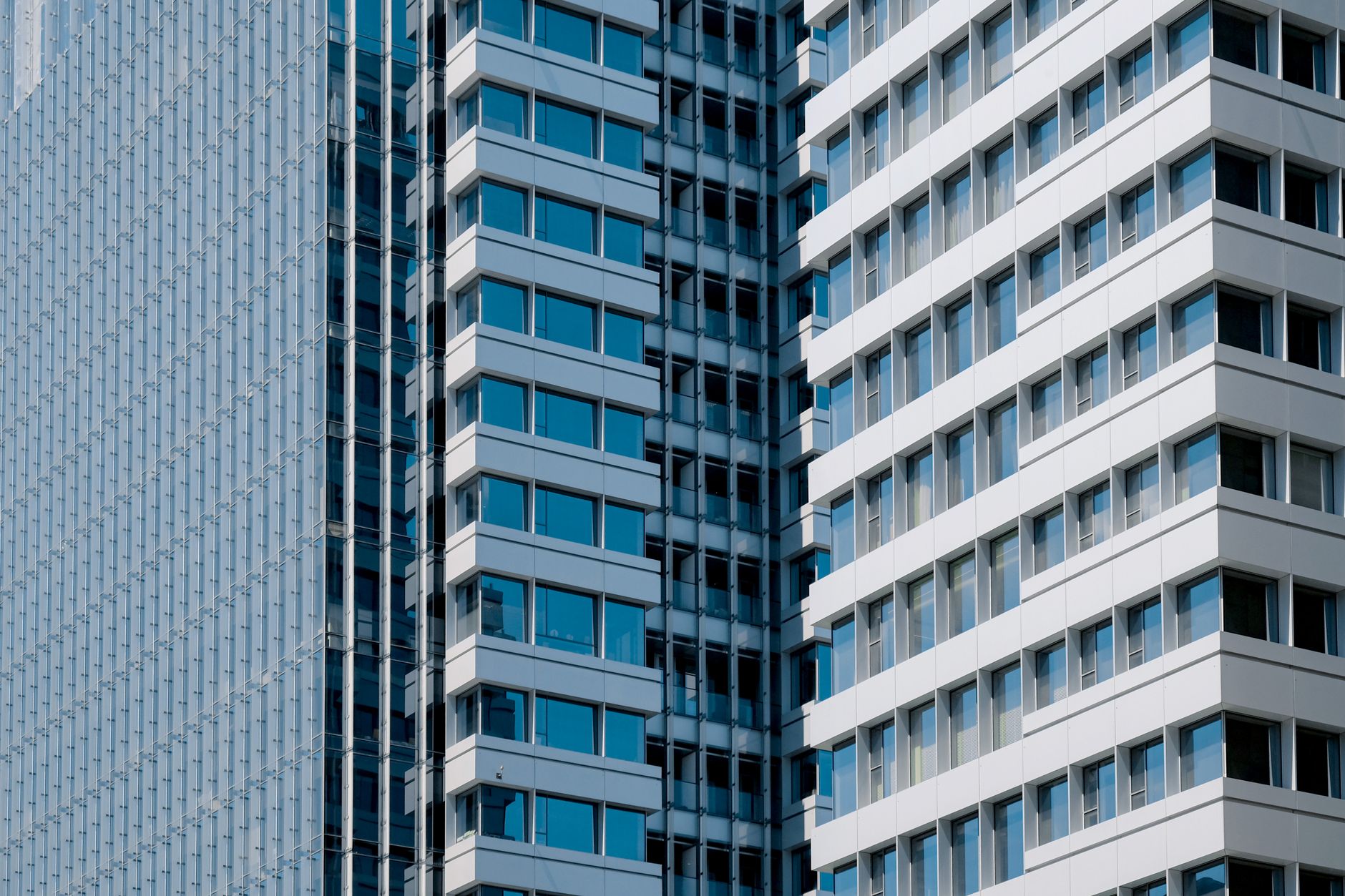 Sleek modern high-rise building with glass windows and geometric design.