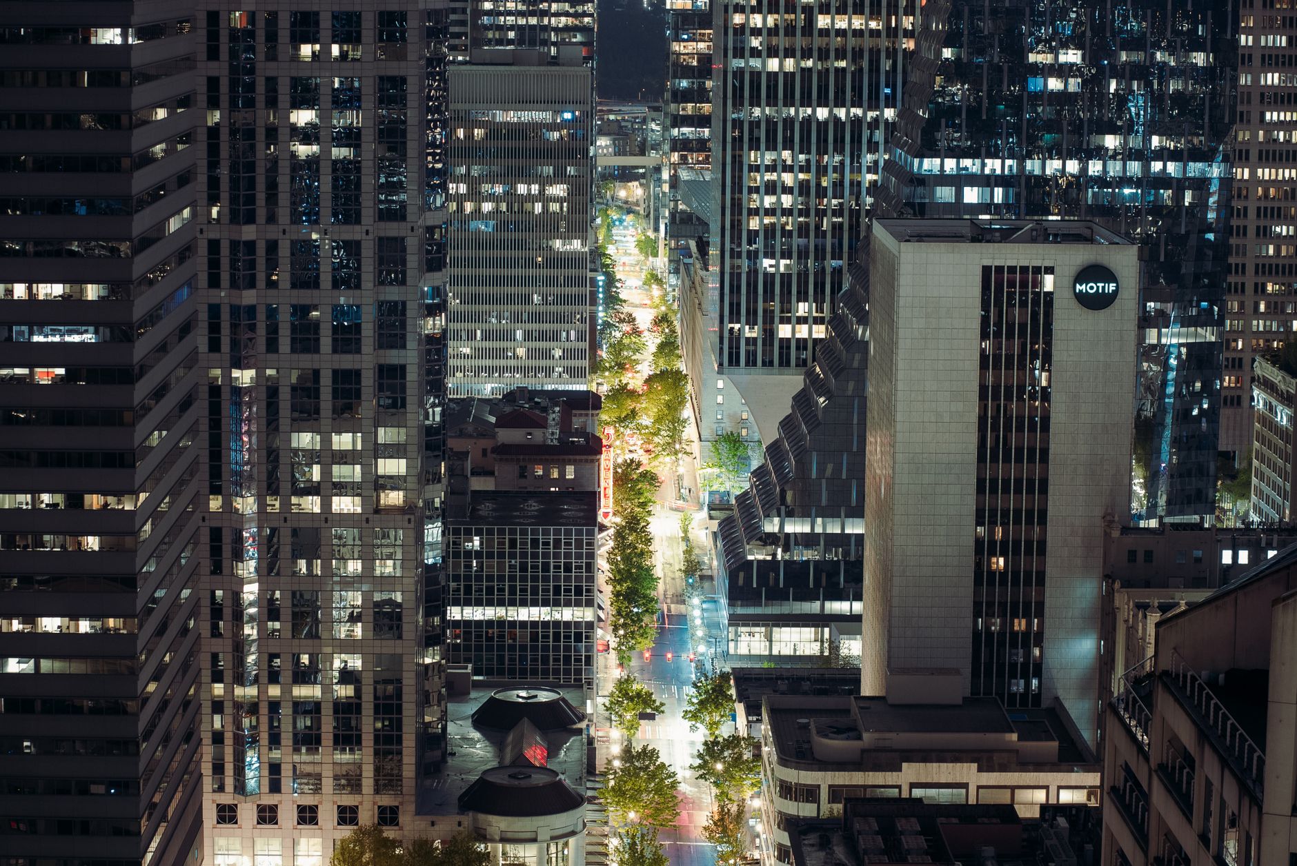 A vibrant nighttime view of Seattle's downtown skyline featuring illuminated skyscrapers.