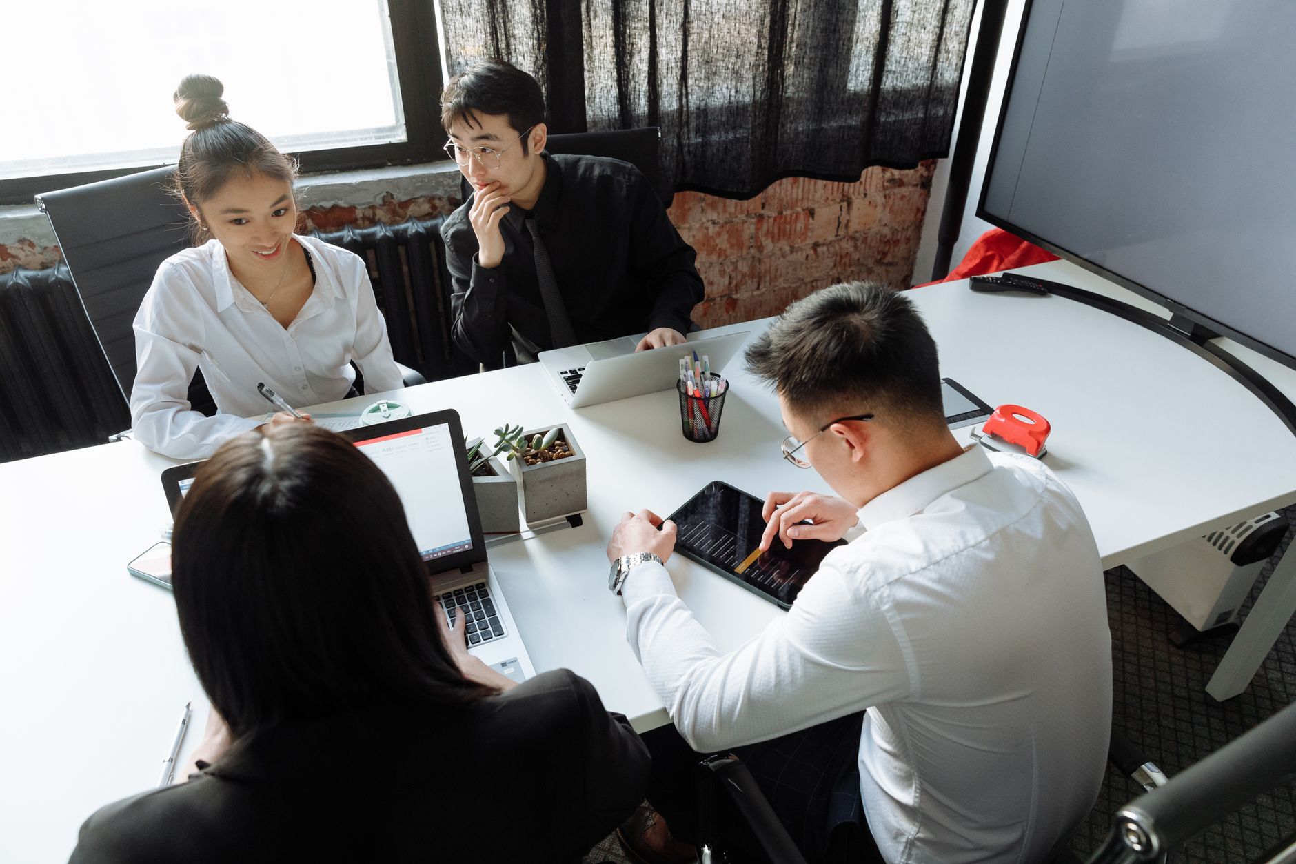 Group of diverse colleagues collaborating in a modern office environment, engaged in a meeting.