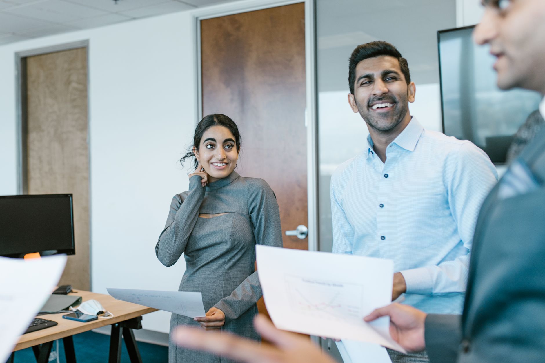 Business professionals engaged in a lively discussion during a team meeting in a modern office.