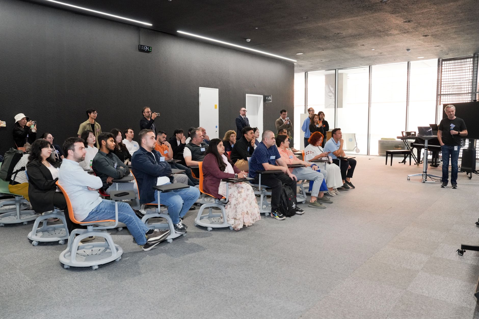 Diverse group attending business presentation in modern conference room setting.