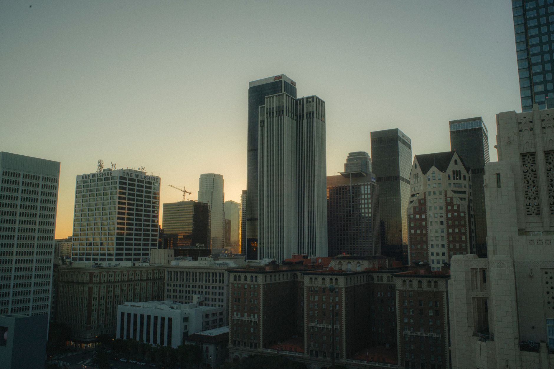 Dramatic view of Los Angeles skyscrapers at sunset, capturing urban architecture and vibrant city life.