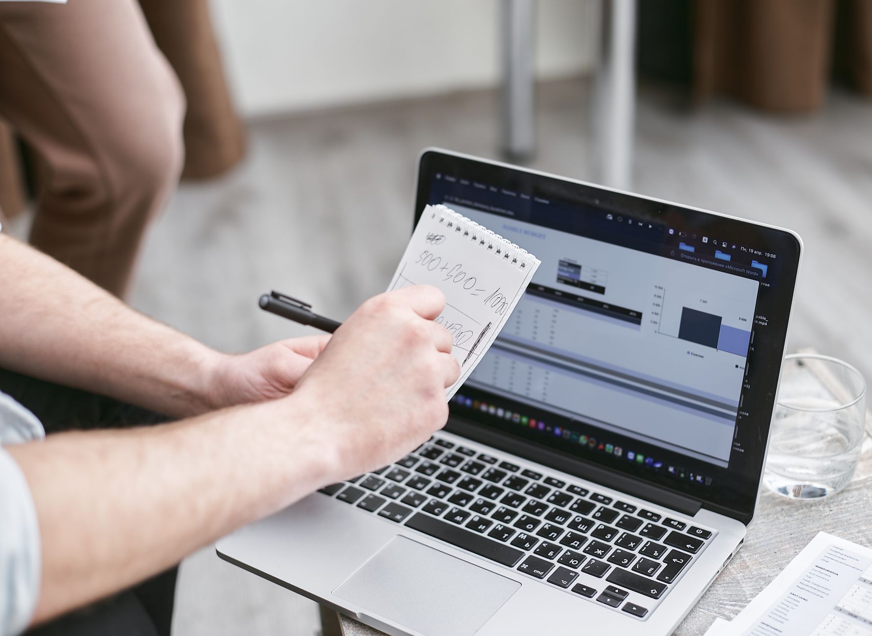Person analyzing data on laptop while taking notes, focusing on market trends.