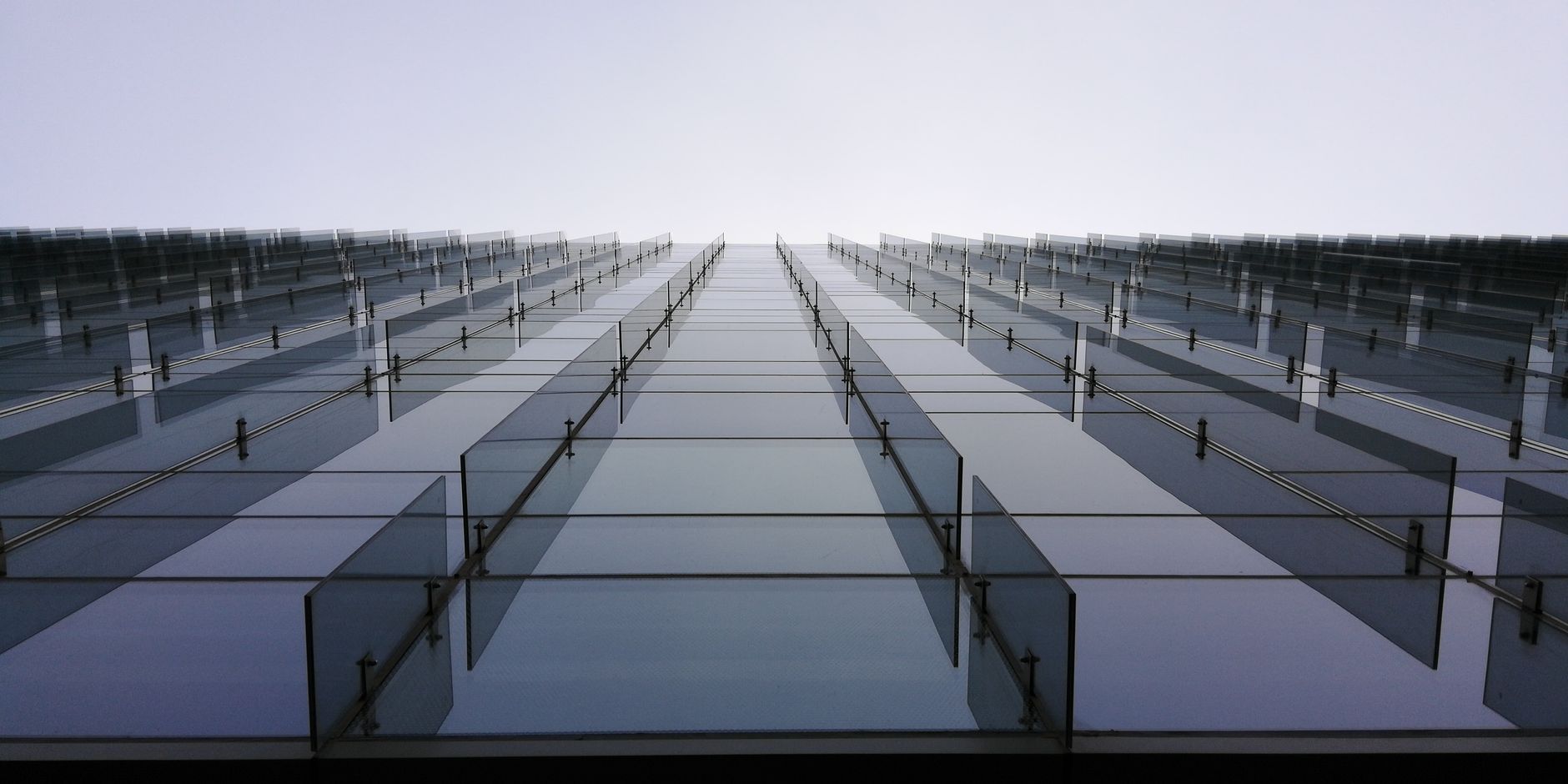 Low angle view of a modern glass facade skyscraper in Pune, India with clear sky.