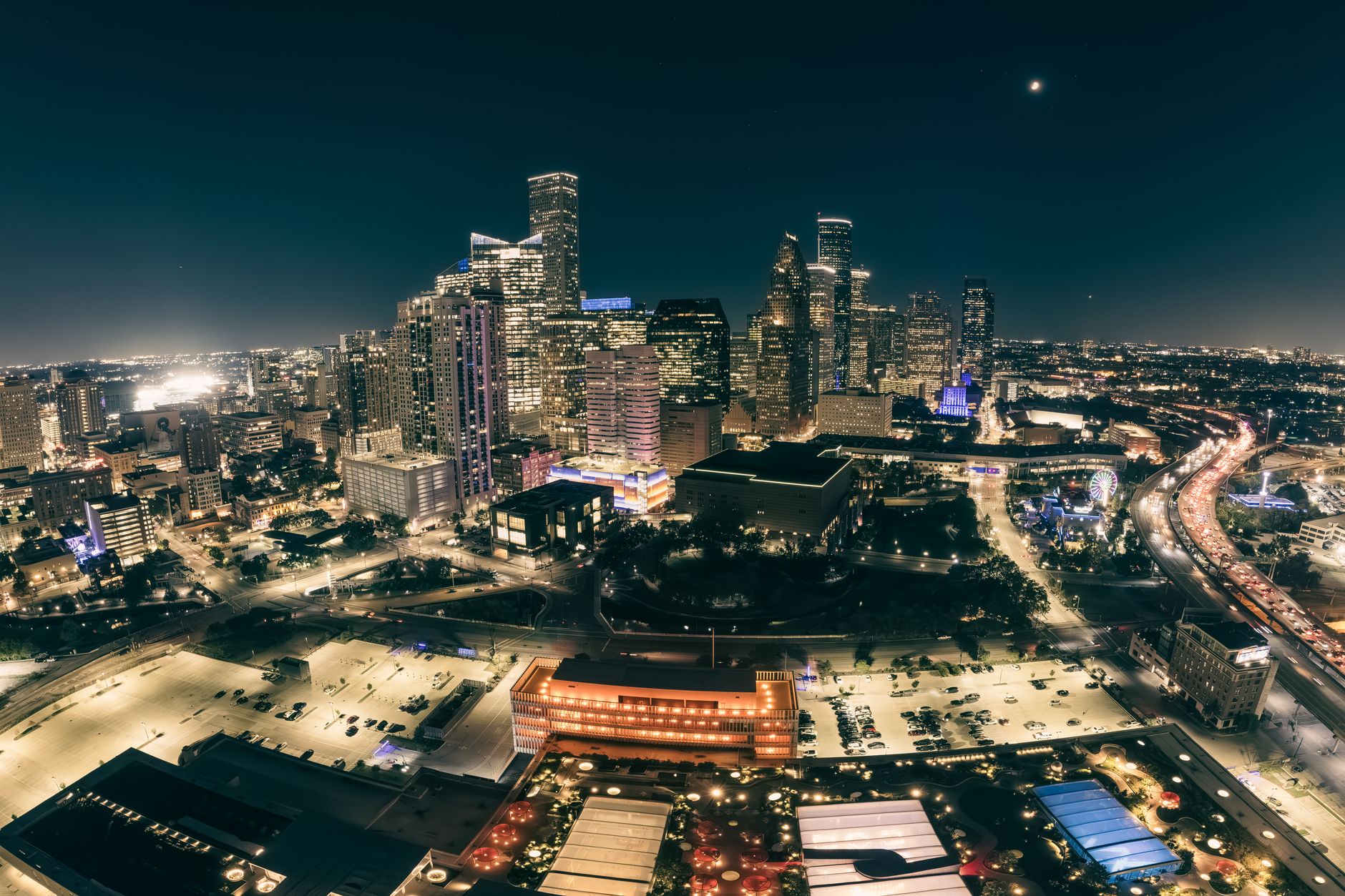 A stunning aerial view of a city skyline illuminated at night, showcasing modern skyscrapers and bustling streets.