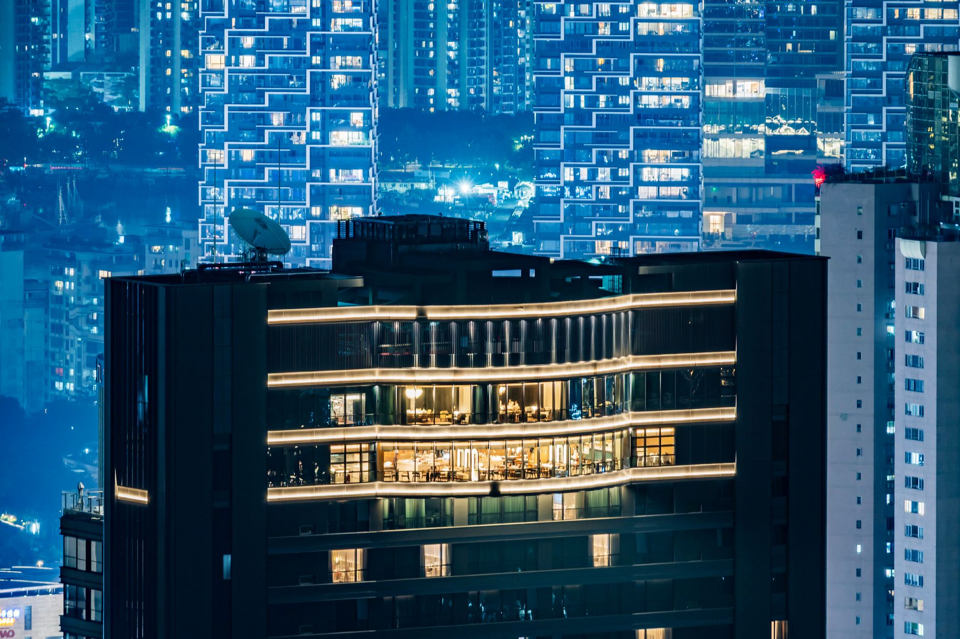 Vibrant nighttime cityscape showcasing modern high-rise architecture with glowing windows.