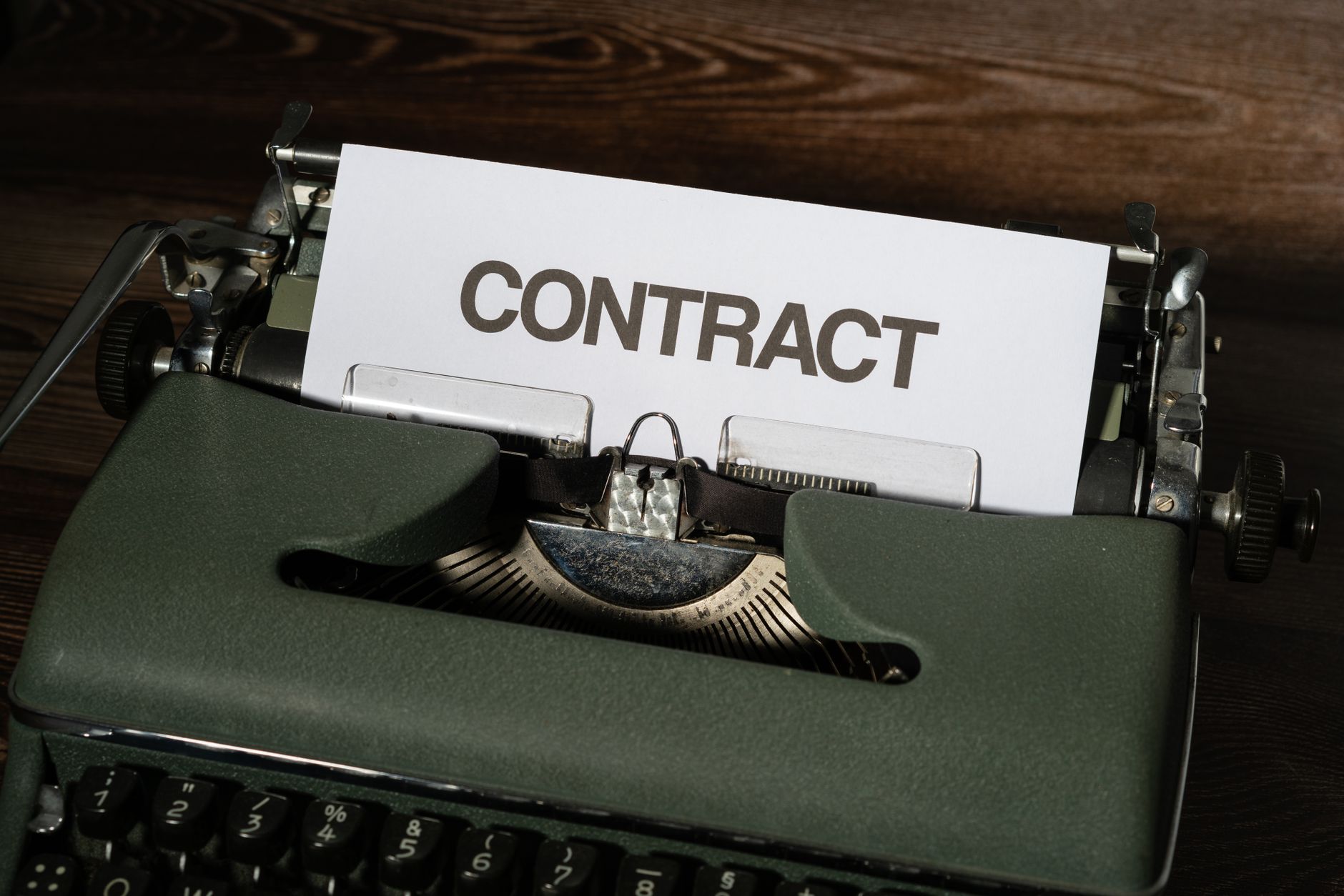 Close-up of a vintage typewriter with a paper labeled 'Contract', evoking a retro office theme.