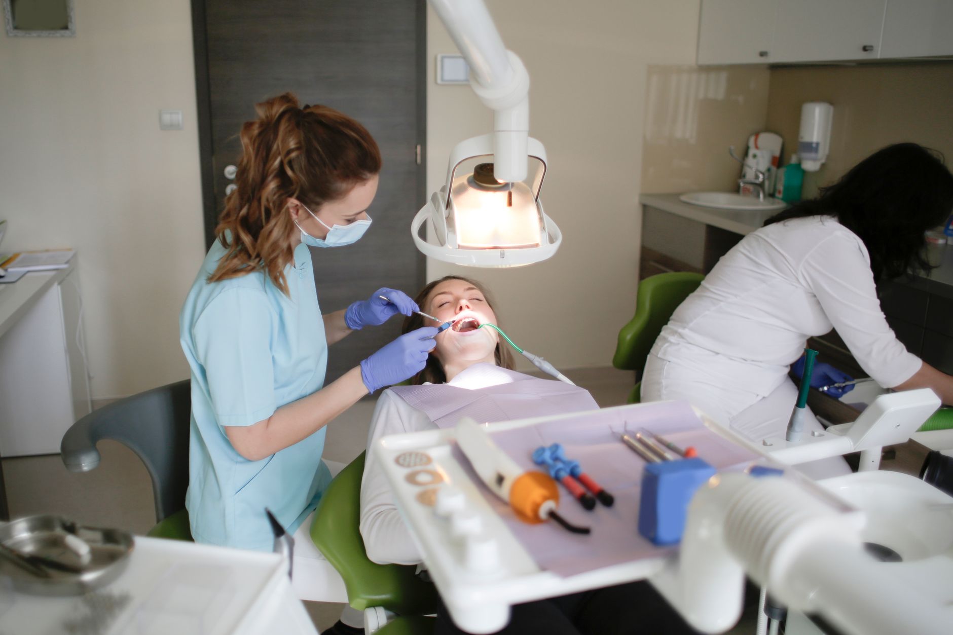 A dentist conducts a dental checkup on a patient in a modern clinic, focusing on oral hygiene.