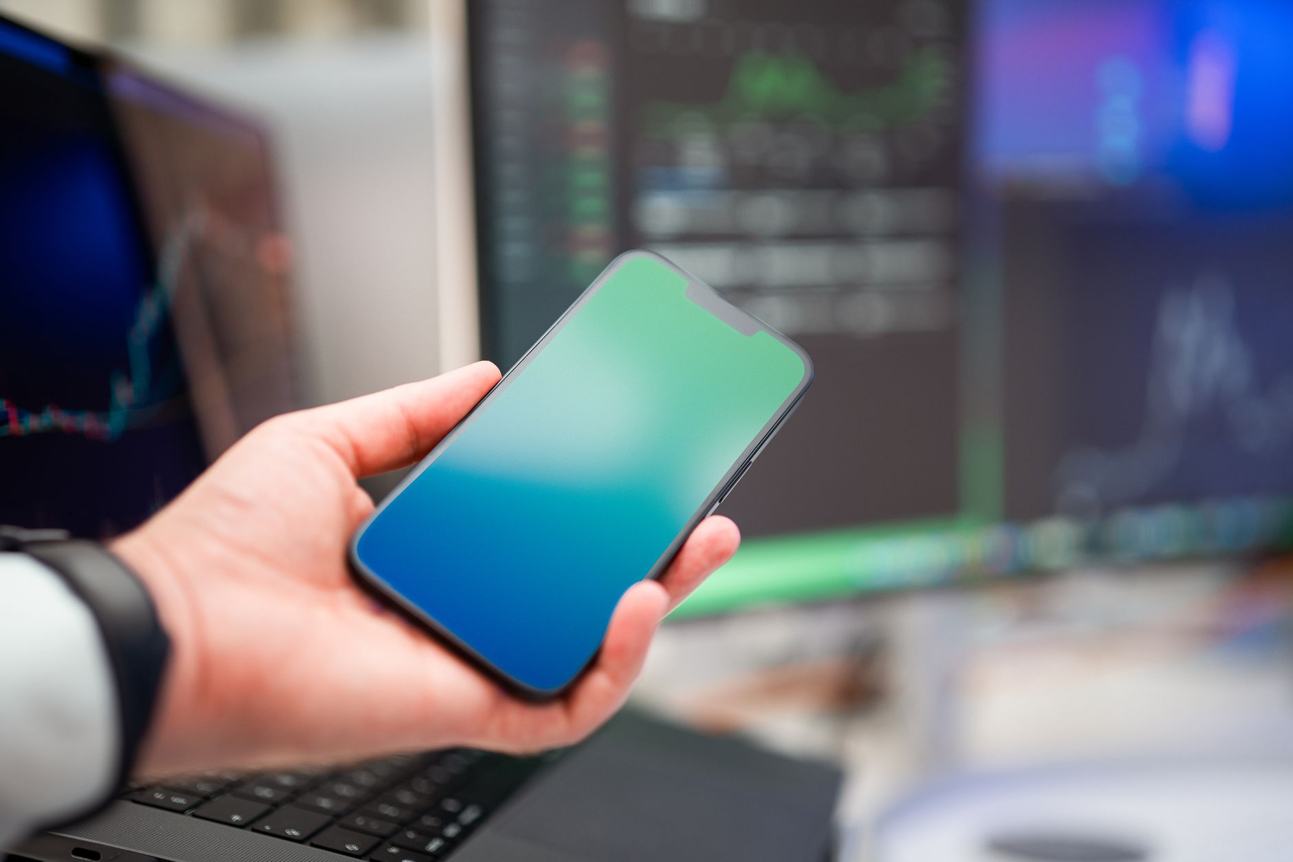 A person holding a smartphone with forex charts displayed, implying modern finance and technology.