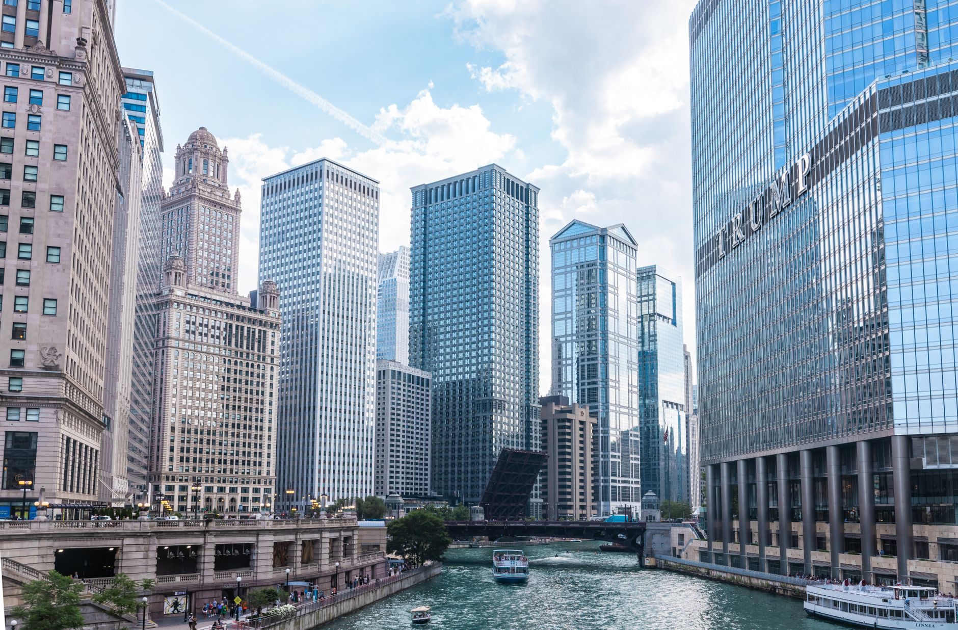 Explore the iconic skyline of Chicago with majestic skyscrapers along the Chicago River on a bright day.