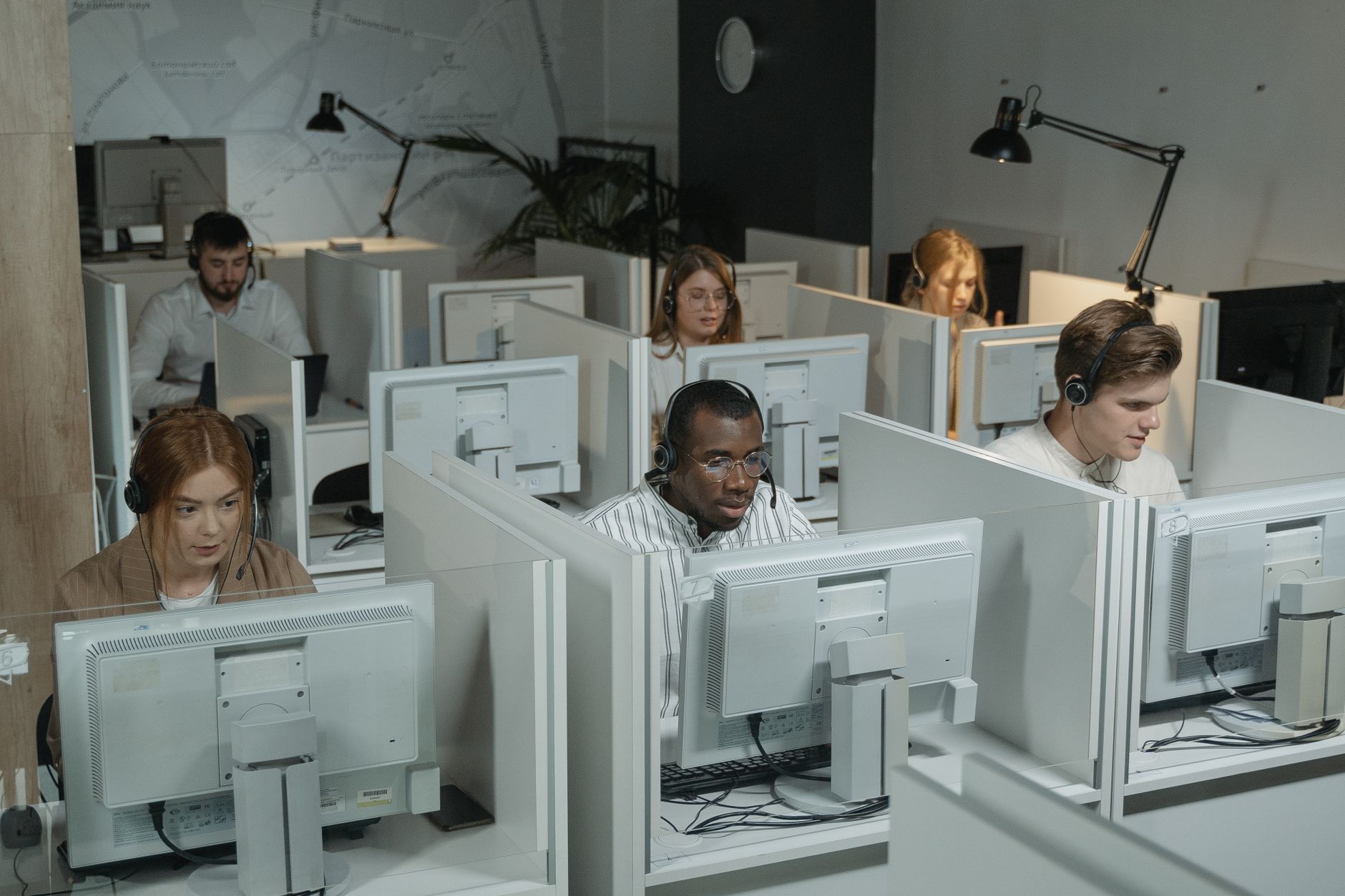 Professional customer support team working with headsets in a modern office environment.