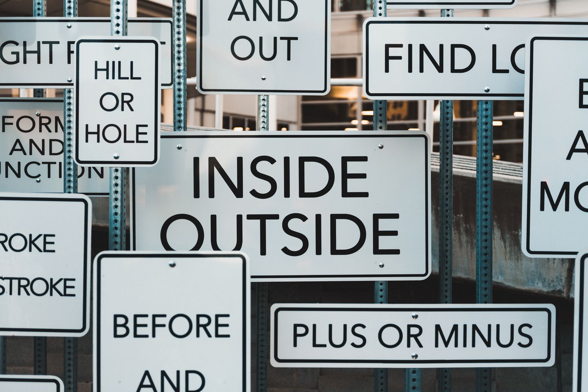 A creative display of street signs in Salt Lake City, showcasing contrasting messages and typography.