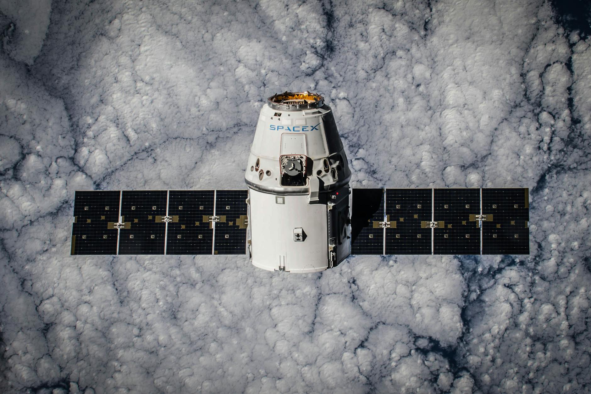 SpaceX Dragon spacecraft in orbit, highlighting advanced space technology with cloud backdrop.