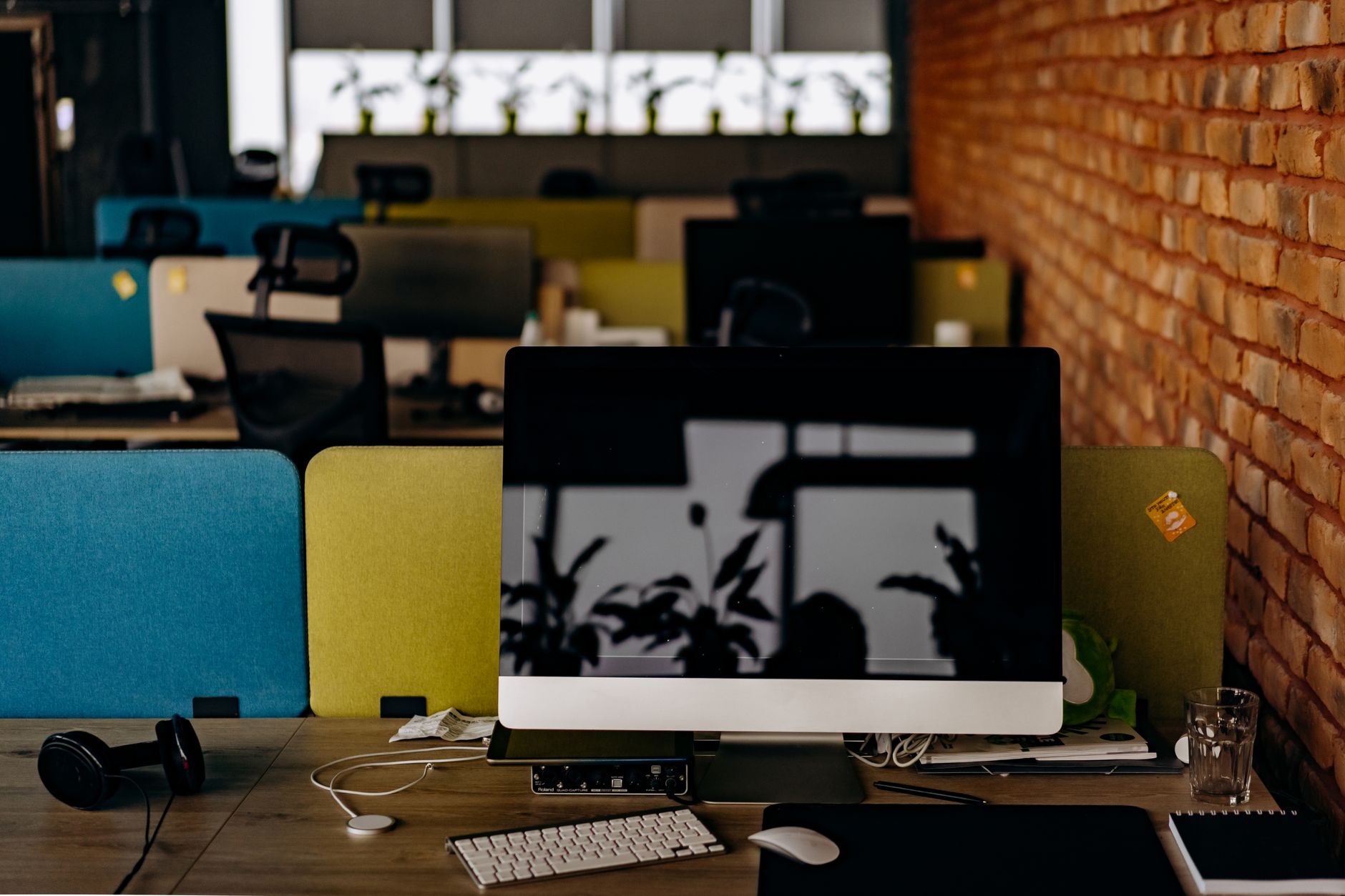 A clean, modern workspace with a computer on a desk in an empty office setting.
