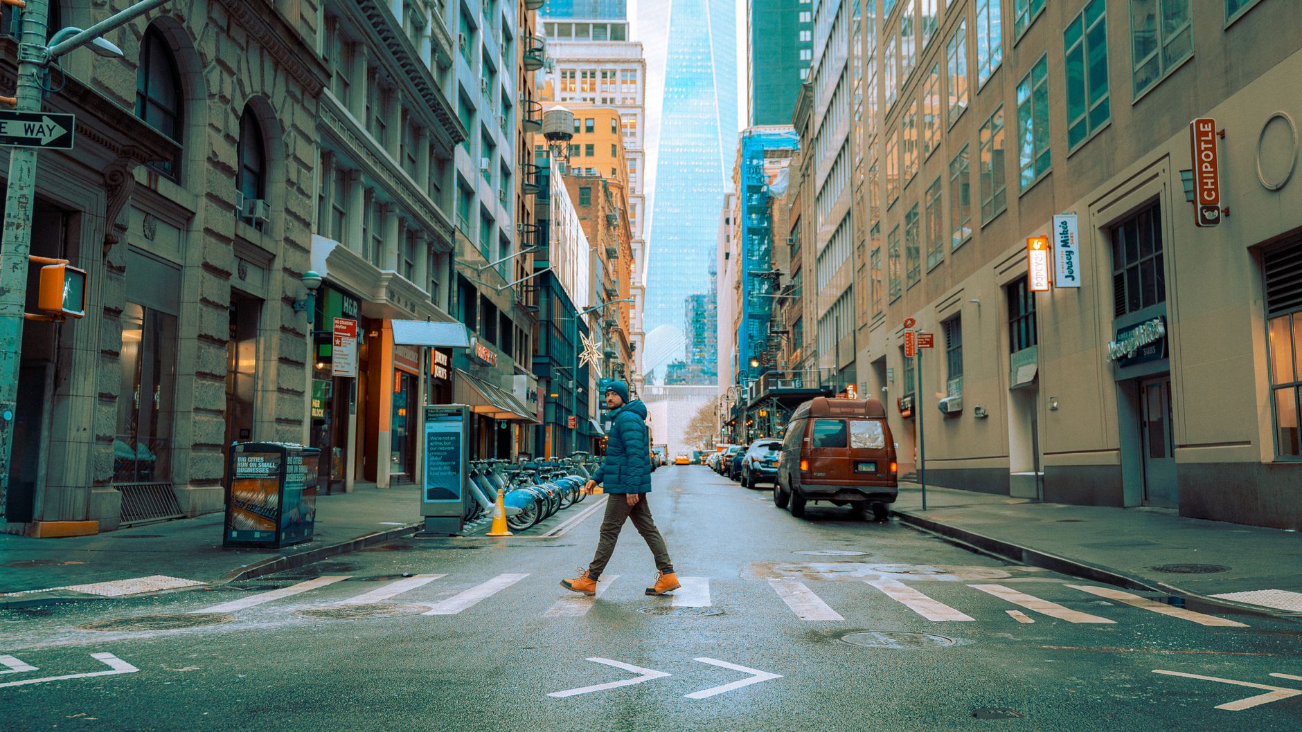 A person crosses a street in downtown Manhattan, New York during winter.