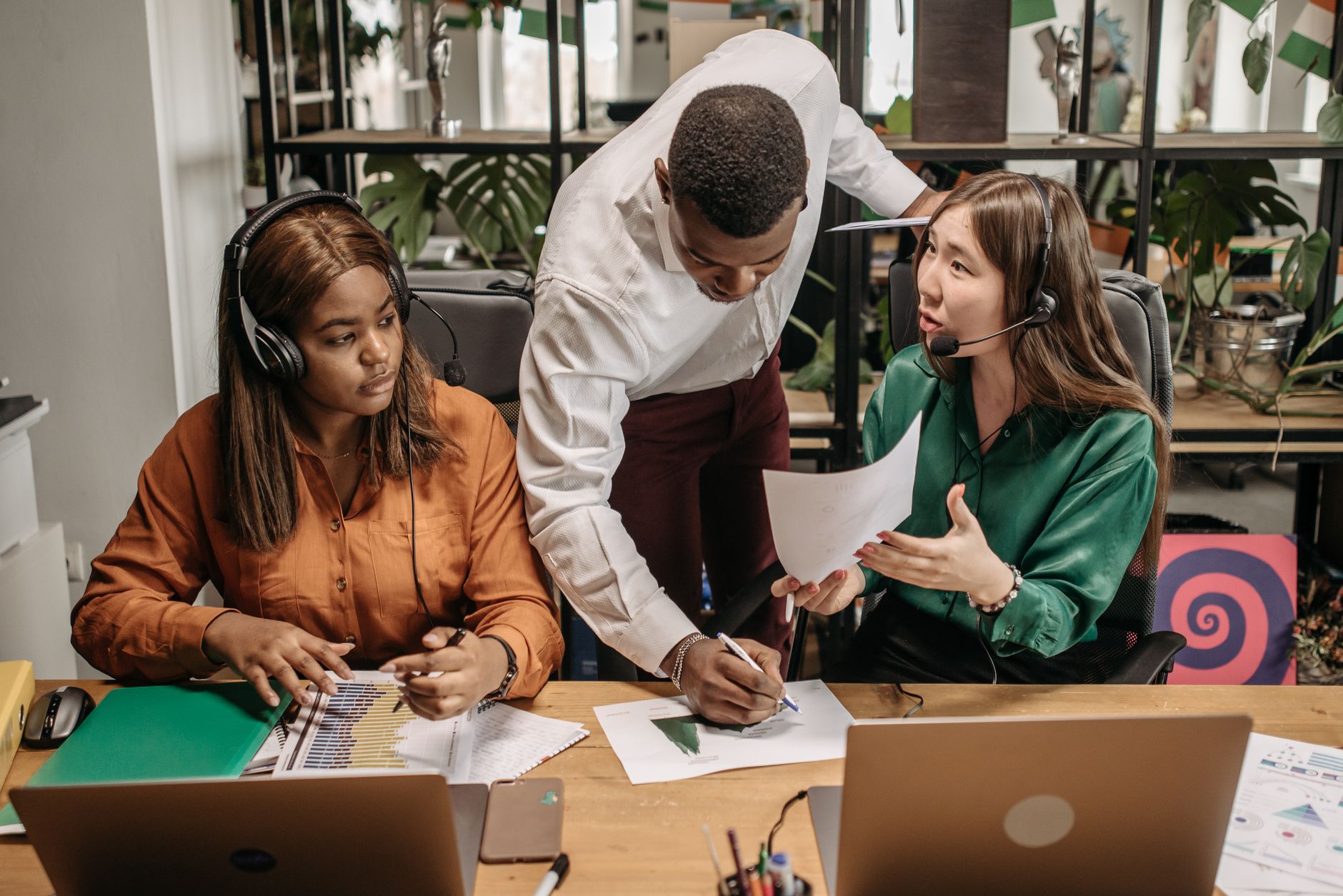 Diverse team collaborating in an office setting with technology and reports.