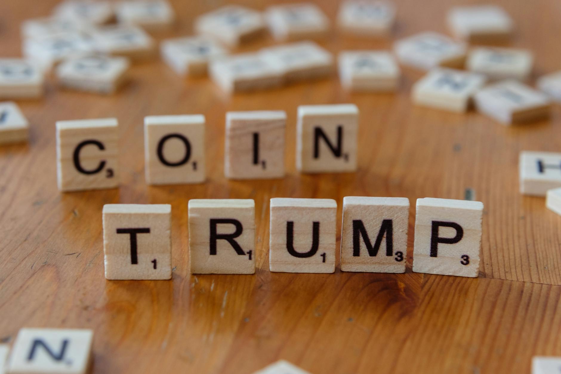 Scrabble tiles spelling 'TRUMP' on a wooden table, creating a political theme.