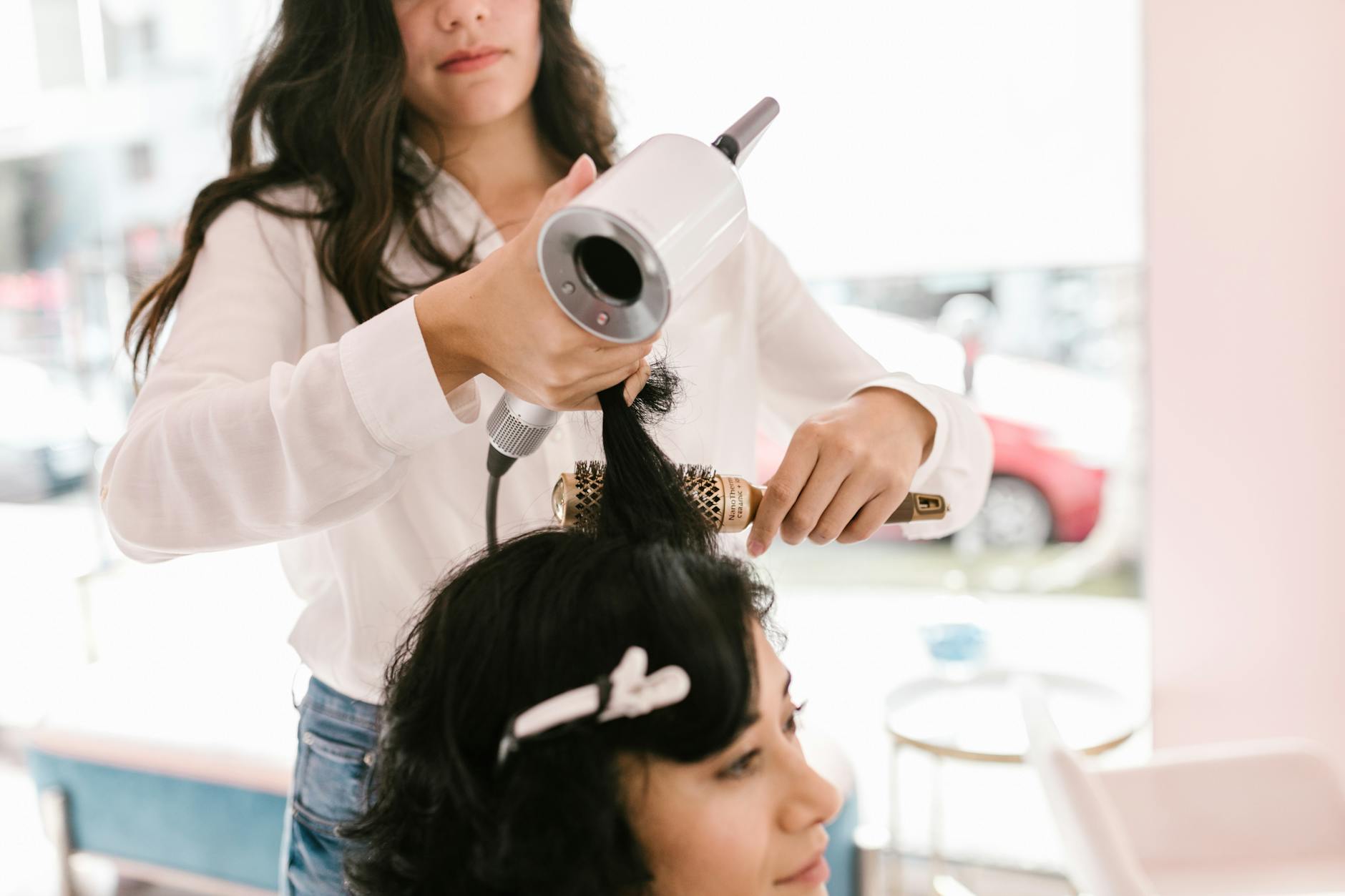 Hair stylist applying keratin treatment to client