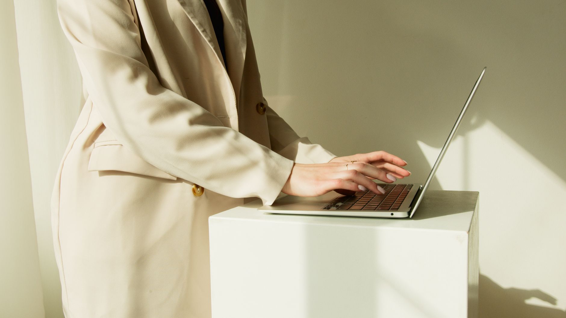 Smiling real estate agent reviewing property listings on laptop with autonomous SEO dashboard visible