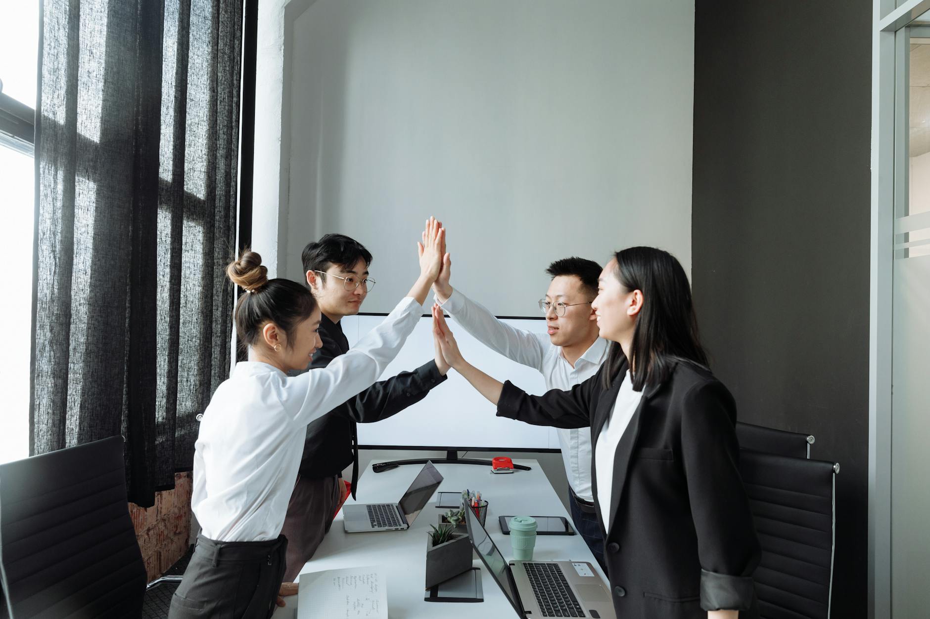 Sales team celebrating success in modern office