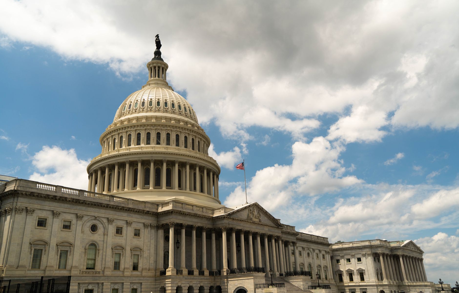 The United States Capitol building dome against a blue sky in Washington, DC, architectural landmark.