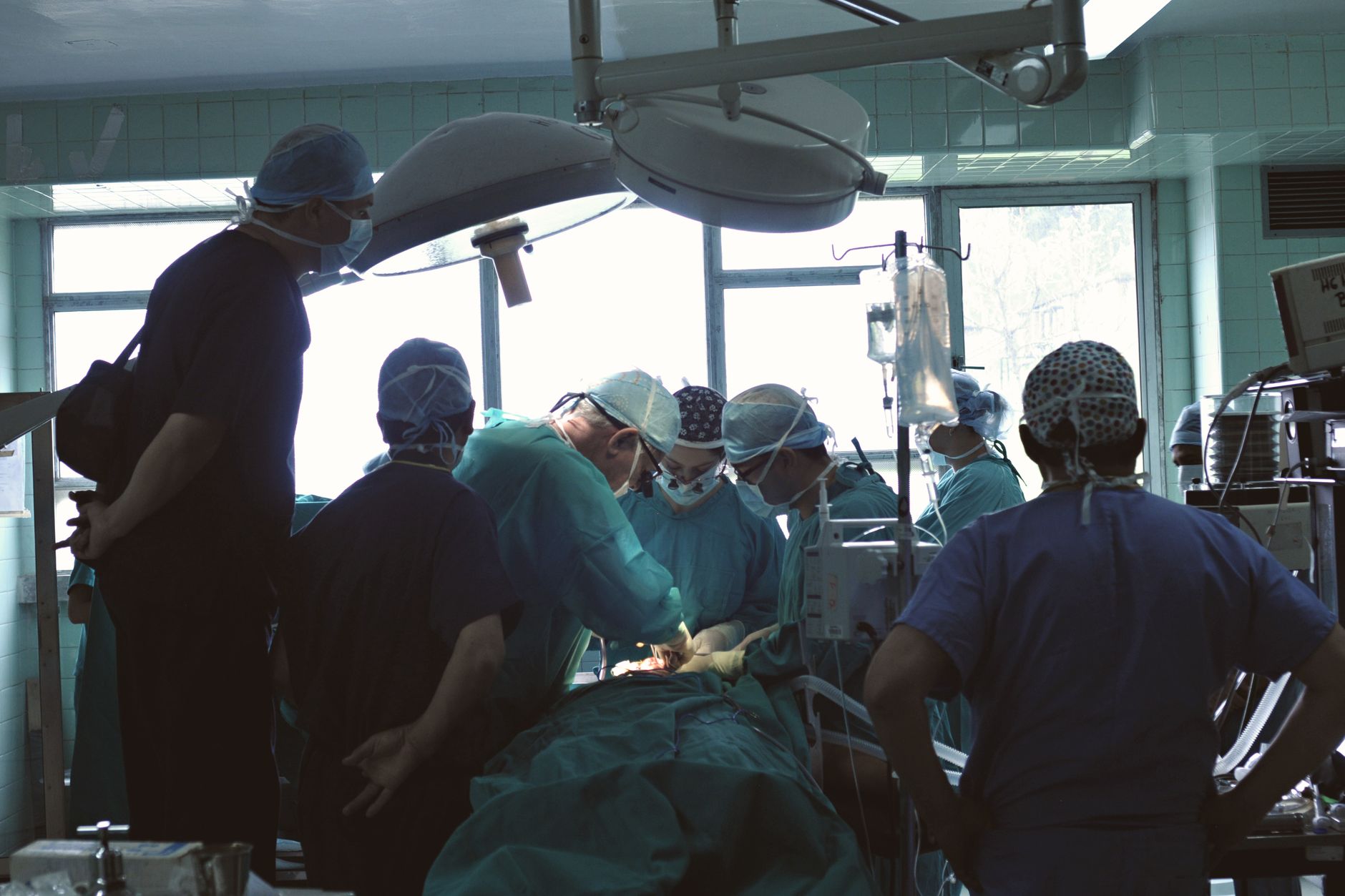 Medical team conducting surgery in a hospital setting with focused attention.