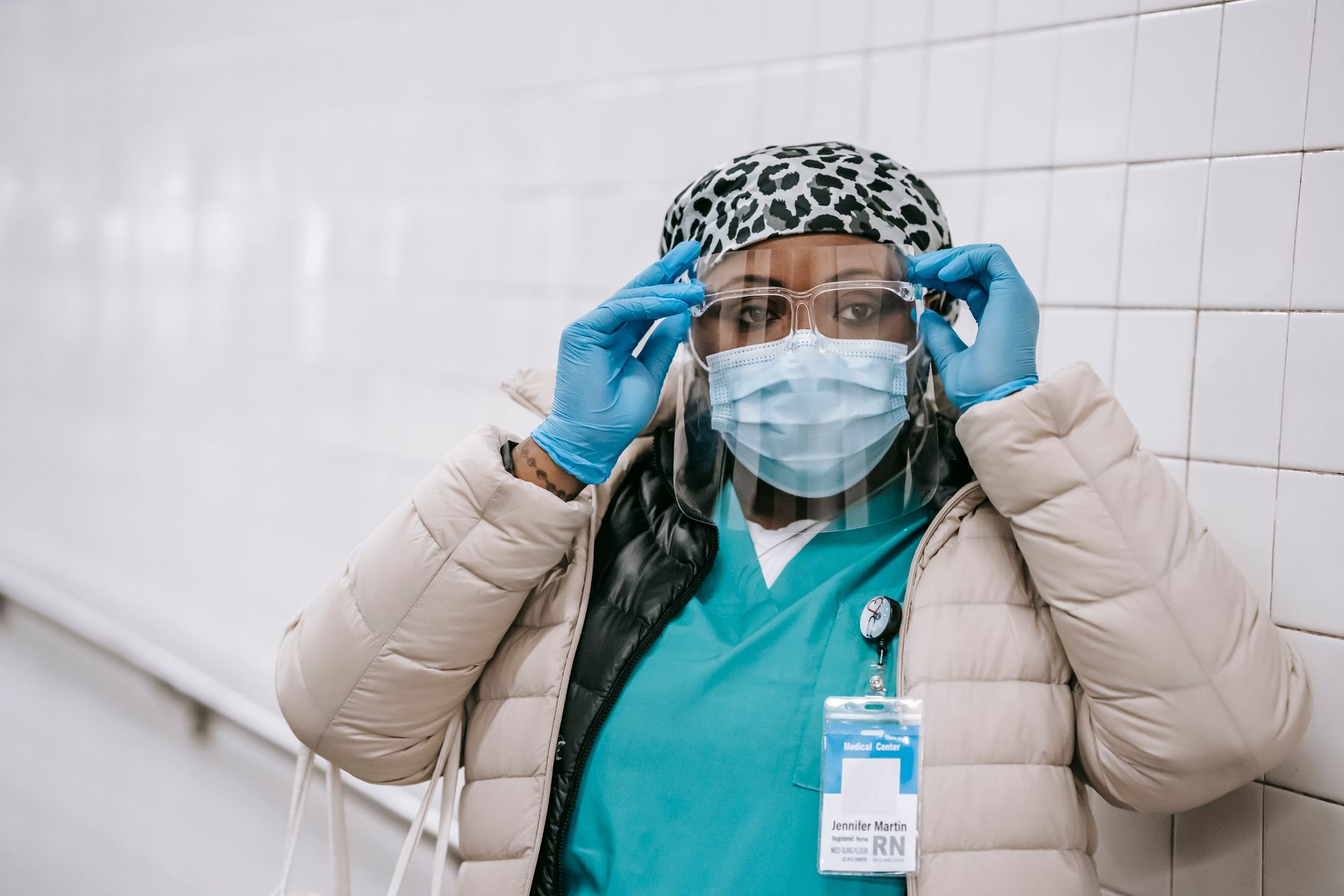 Serious black female dressing up protective mask and glasses before working in hospital