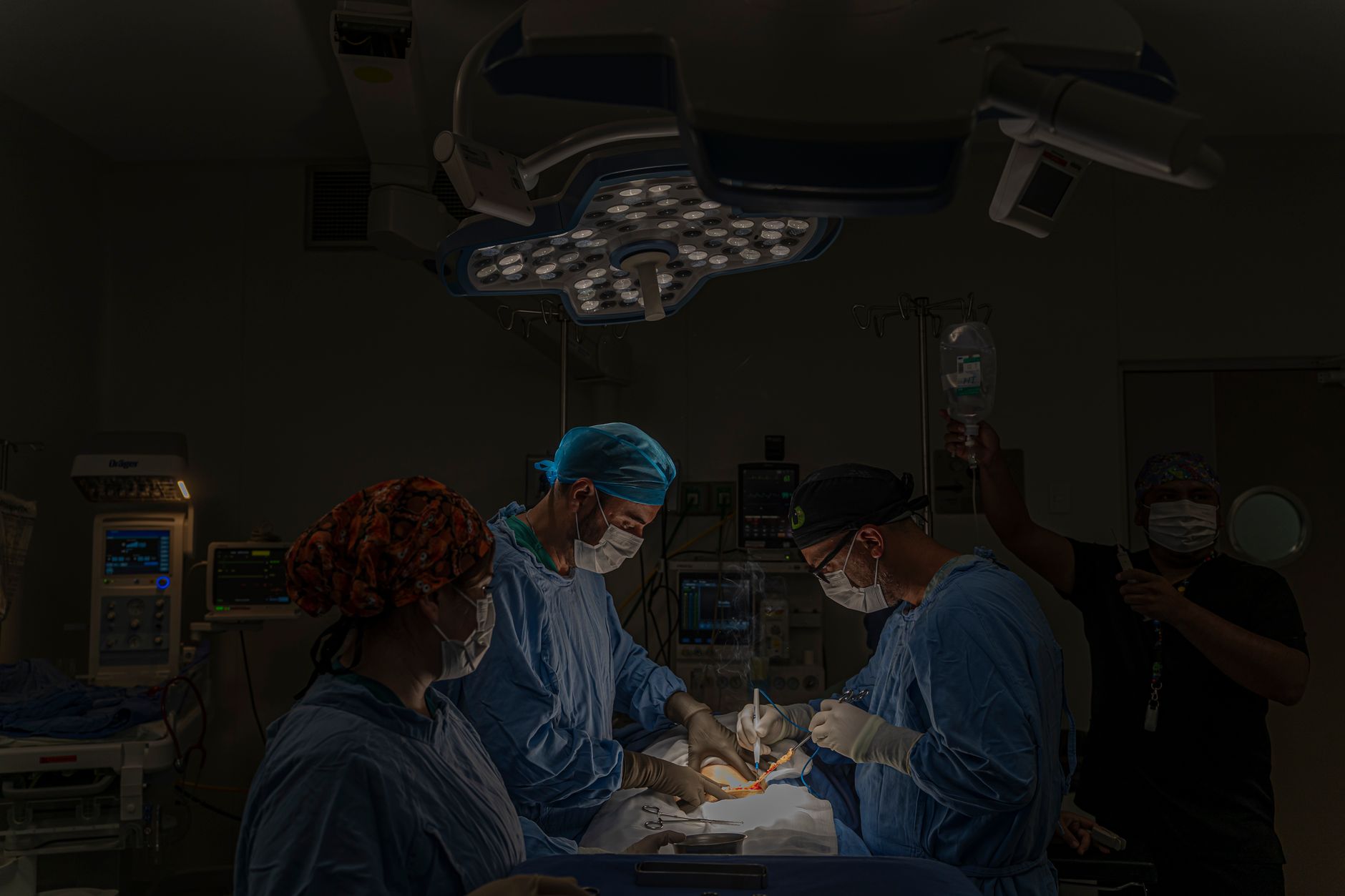 A surgical team conducts an operation in a well-equipped hospital operating room in Mexico.