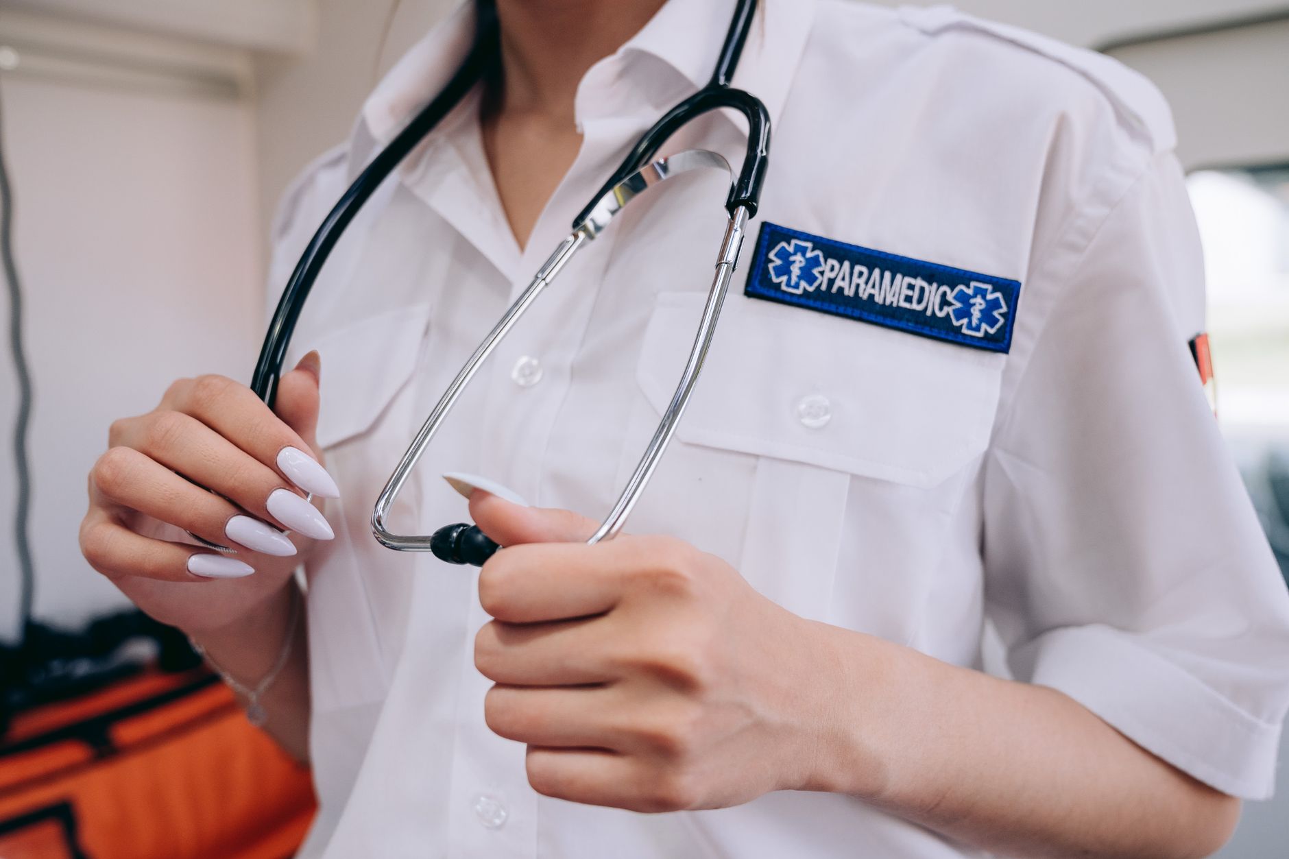 A paramedic in uniform holds a stethoscope, ready for medical assistance.