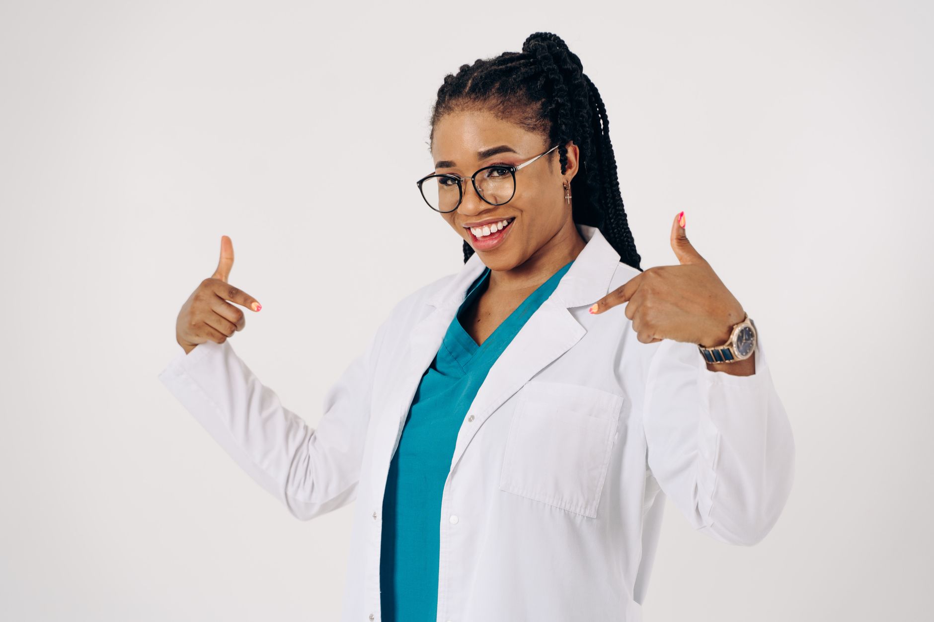 Smiling female doctor proudly pointing at her white lab coat.