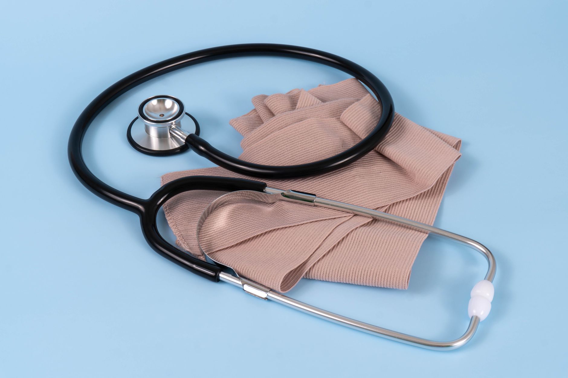 A stethoscope and bandage on a blue background, symbolizing healthcare and medical care.