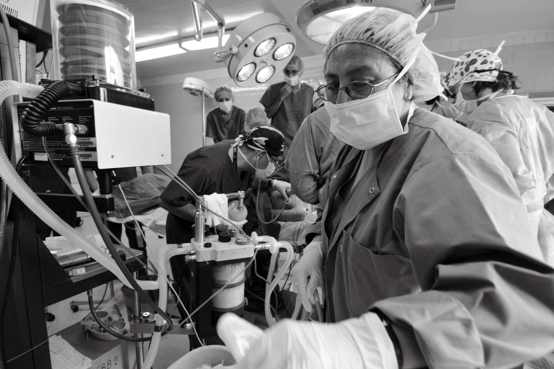Healthcare professionals performing surgery in a busy operating room.