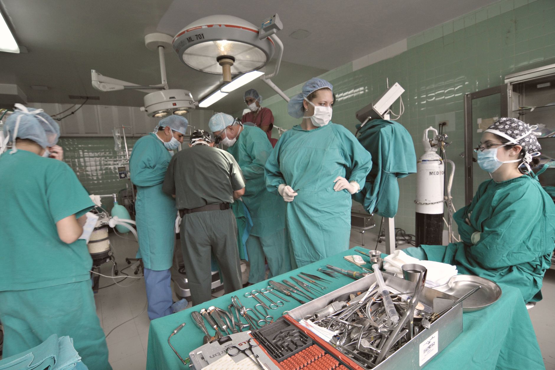 A diverse group of surgeons collaborates in a busy operating room, showcasing teamwork and medical precision.