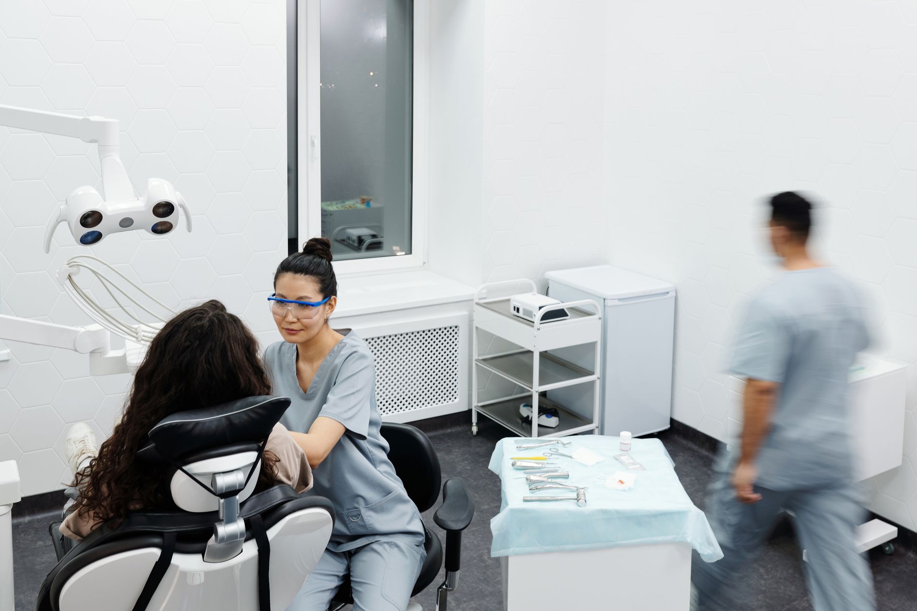 A professional dentist in a modern clinic attending to a patient, showcasing dental care.