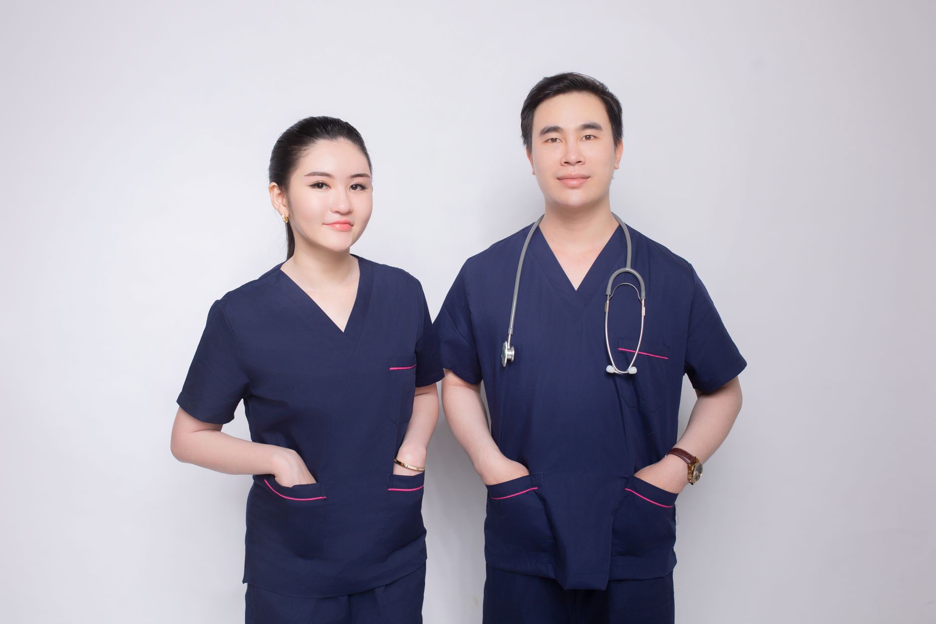 Portrait of a confident male and female medical practitioners in uniform with stethoscope.