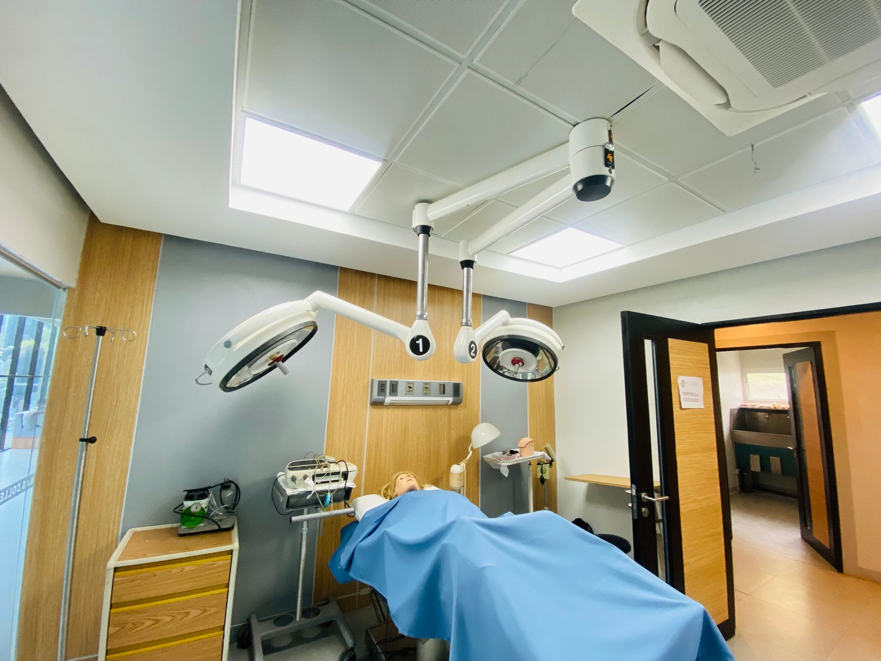 Hospital room showcasing a medical mannequin under surgical lights.